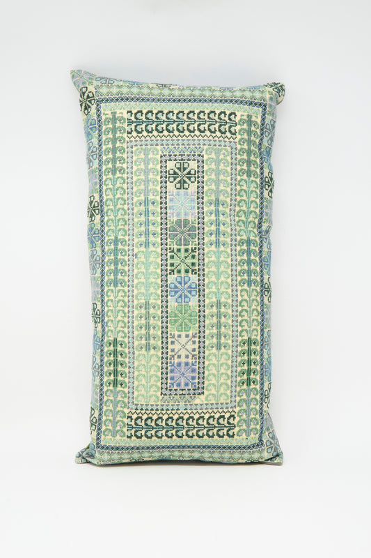 The Yasmin Hand Embroidered Pillow in Olive and Slate by Kissweh features geometric patterns in blue, green, and cream on white Belgian linen.