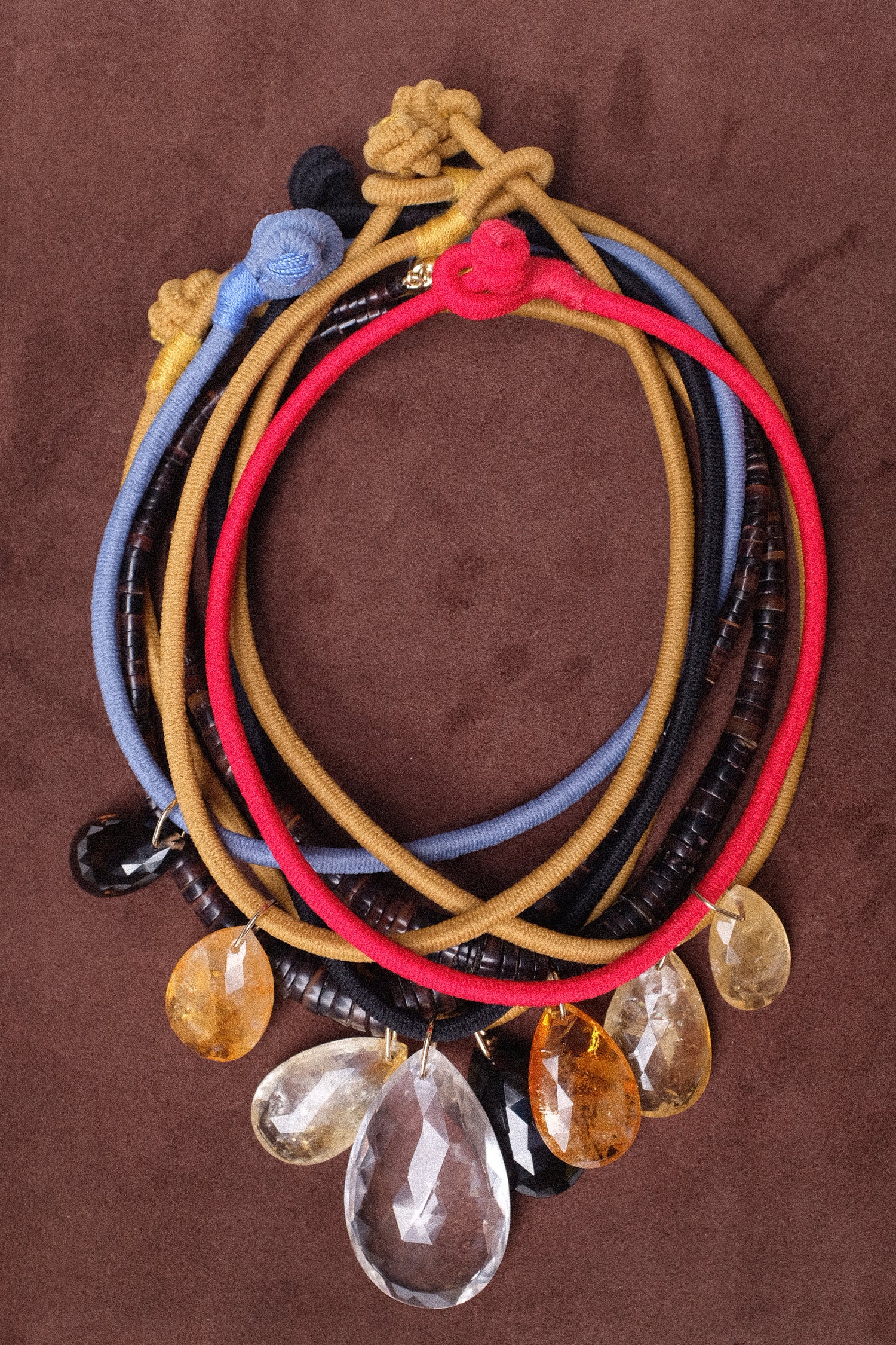 An image of Laoli's necklaces on brown suede.