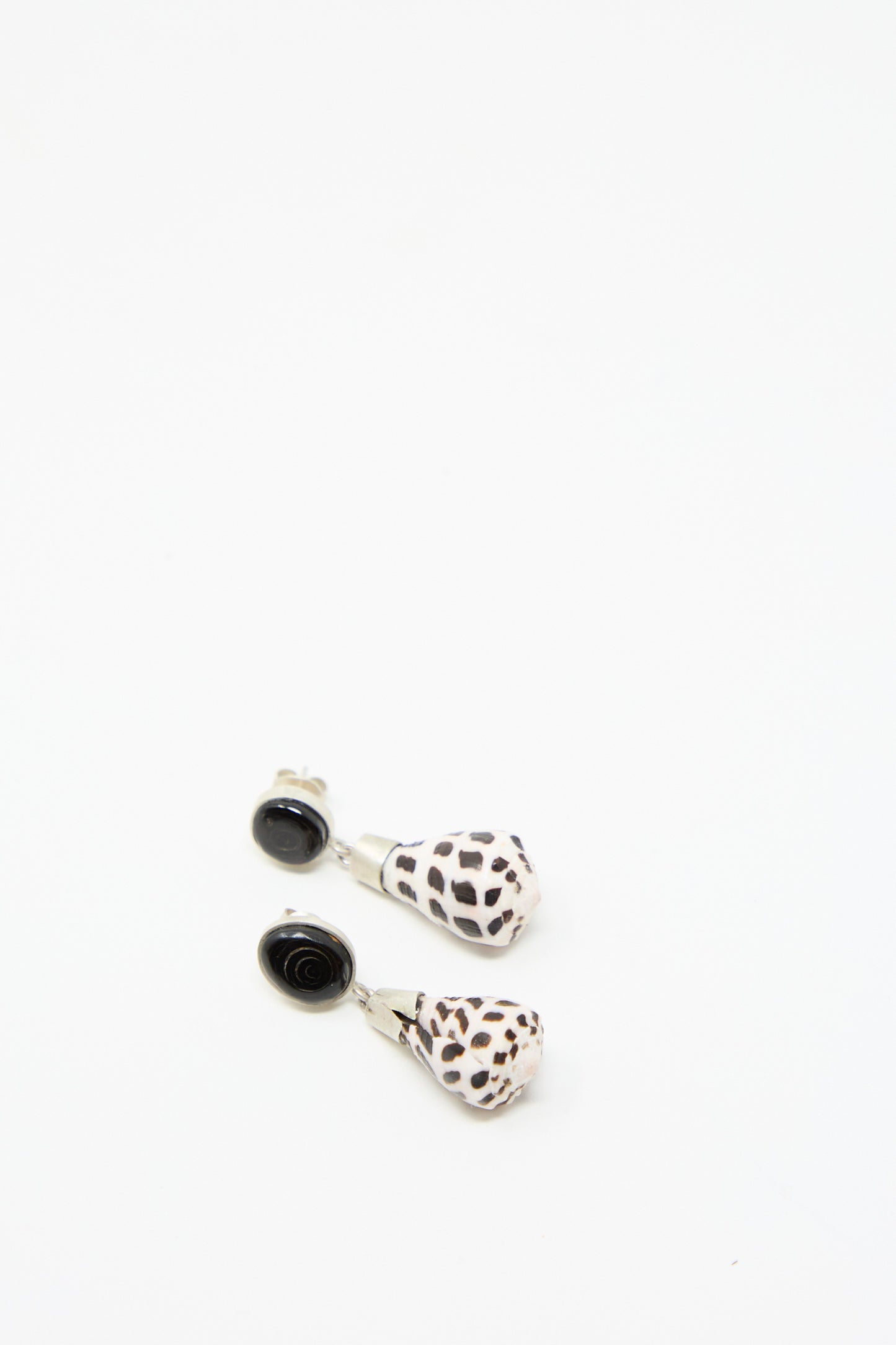 The Sterling Silver No. 09 Earrings by La Ma r, featuring a black and white shell swirl on a white background.