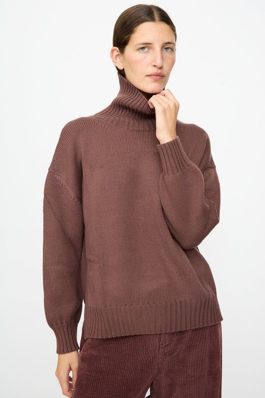 A woman wears the Labo.Art Fiore Sweater in Sasso, a luxurious cashwool knit crafted in Italy, paired with matching corduroy pants. Against a plain light background, this refined ensemble highlights timeless style and the exceptional quality of Italian-made garments.
