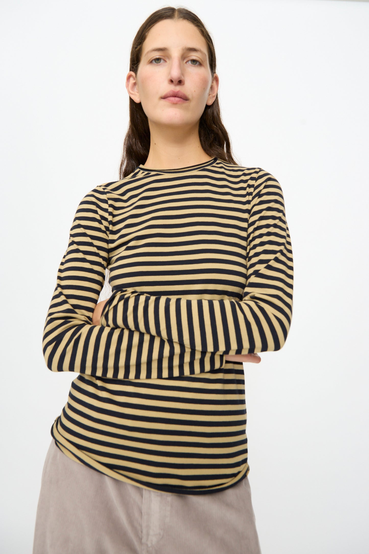 A person stands with arms crossed against a plain white background, wearing the Labo.Art Striped Jersey Basic Longsleeve in Fennec. 