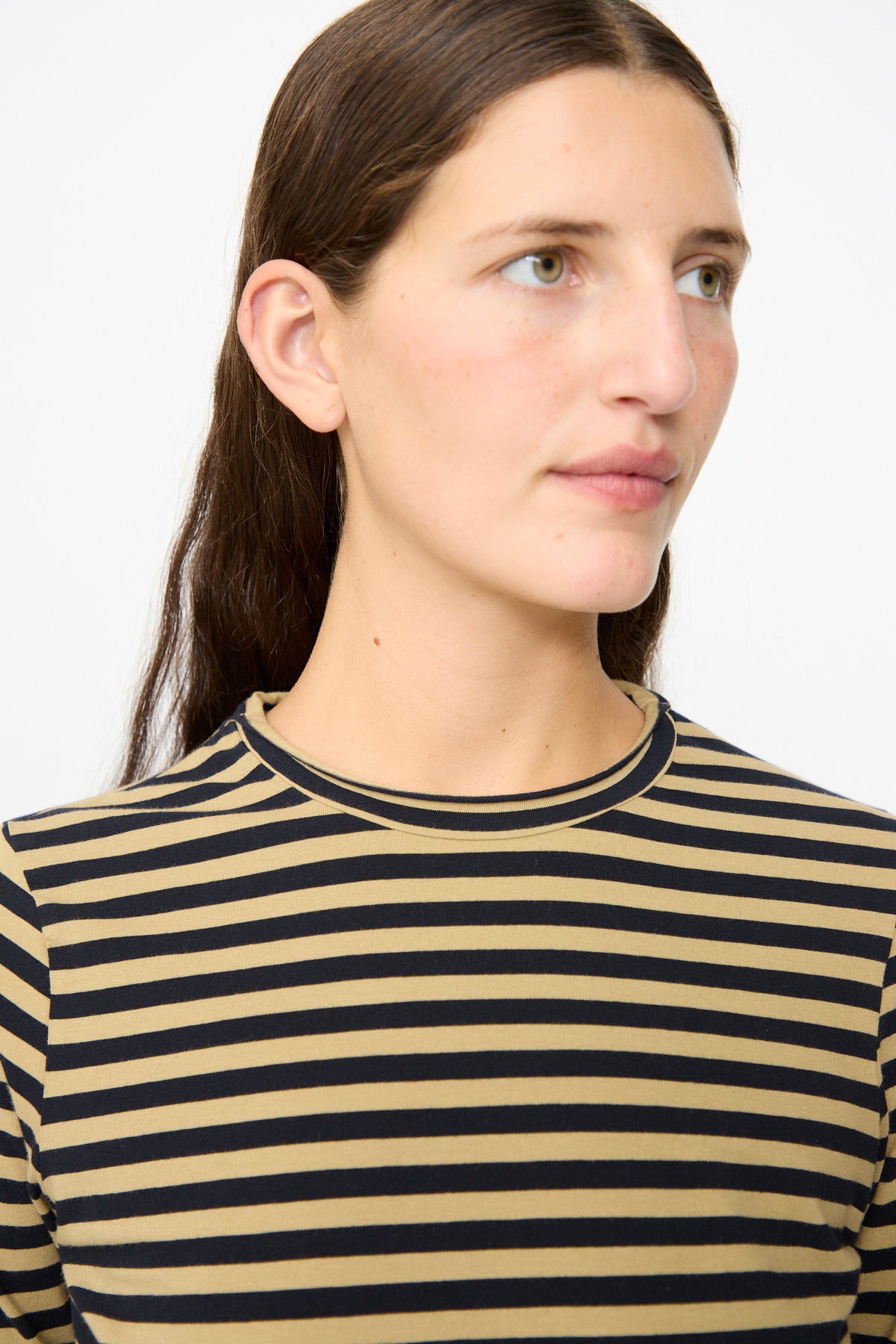 A person with long brown hair wears the Labo.Art Striped Jersey Basic Longsleeve in Fennec, looking slightly to the right against a plain light background.