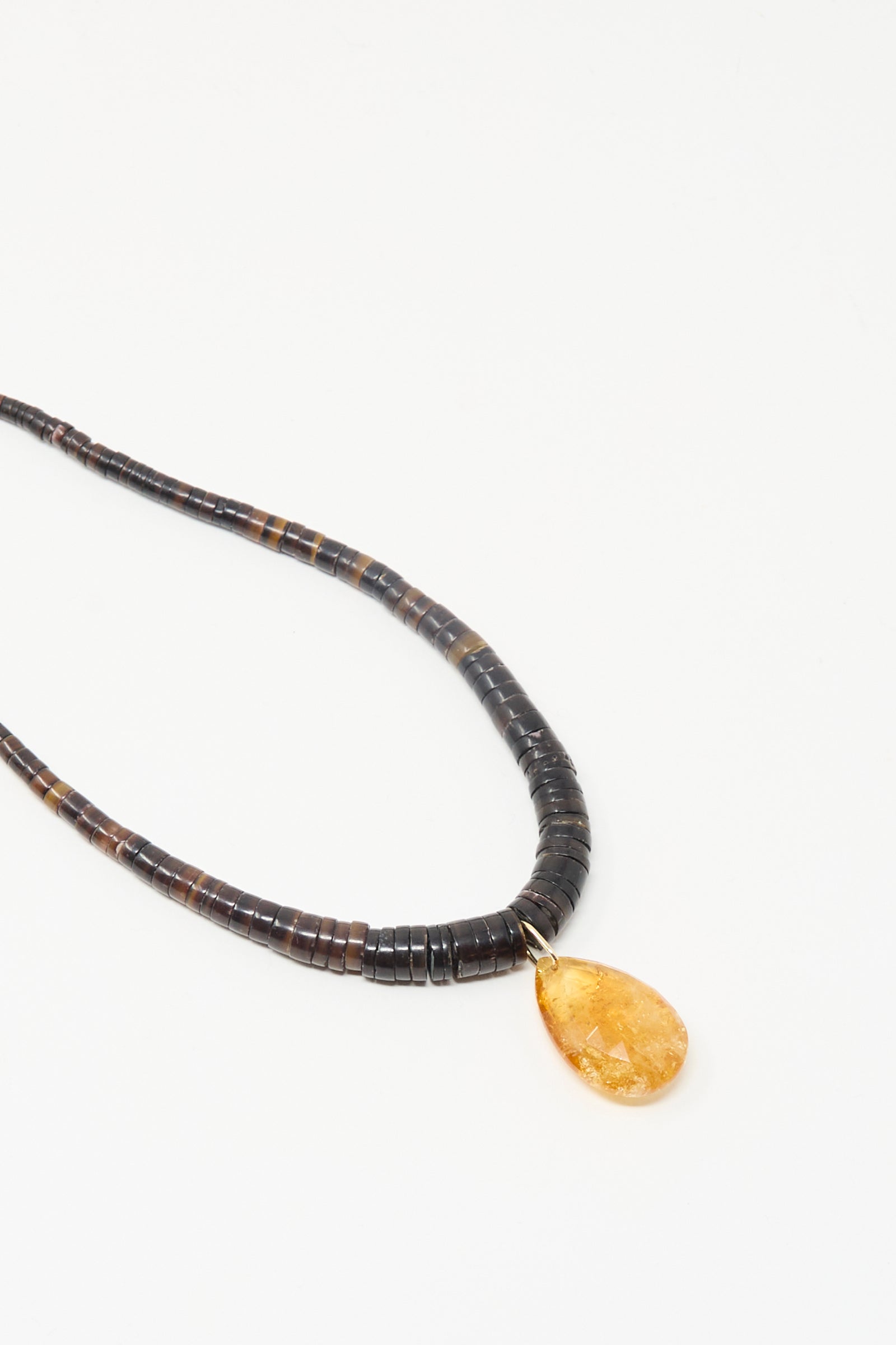 The Drop Collar in Sunset by Laoli: a handmade citrine necklace with dark round beads and a single yellow teardrop pendant, displayed on a white background.