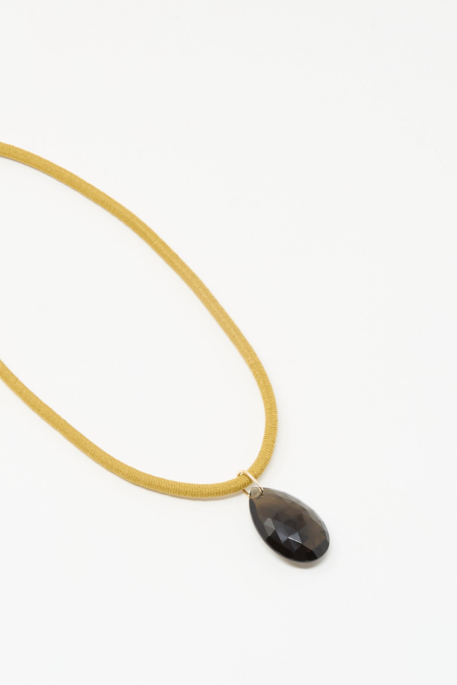 The Drop Cord in Tan and Smoky Quartz by Laoli features a handmade teardrop-shaped smoky quartz pendant on a tan cord, displayed against a white background.