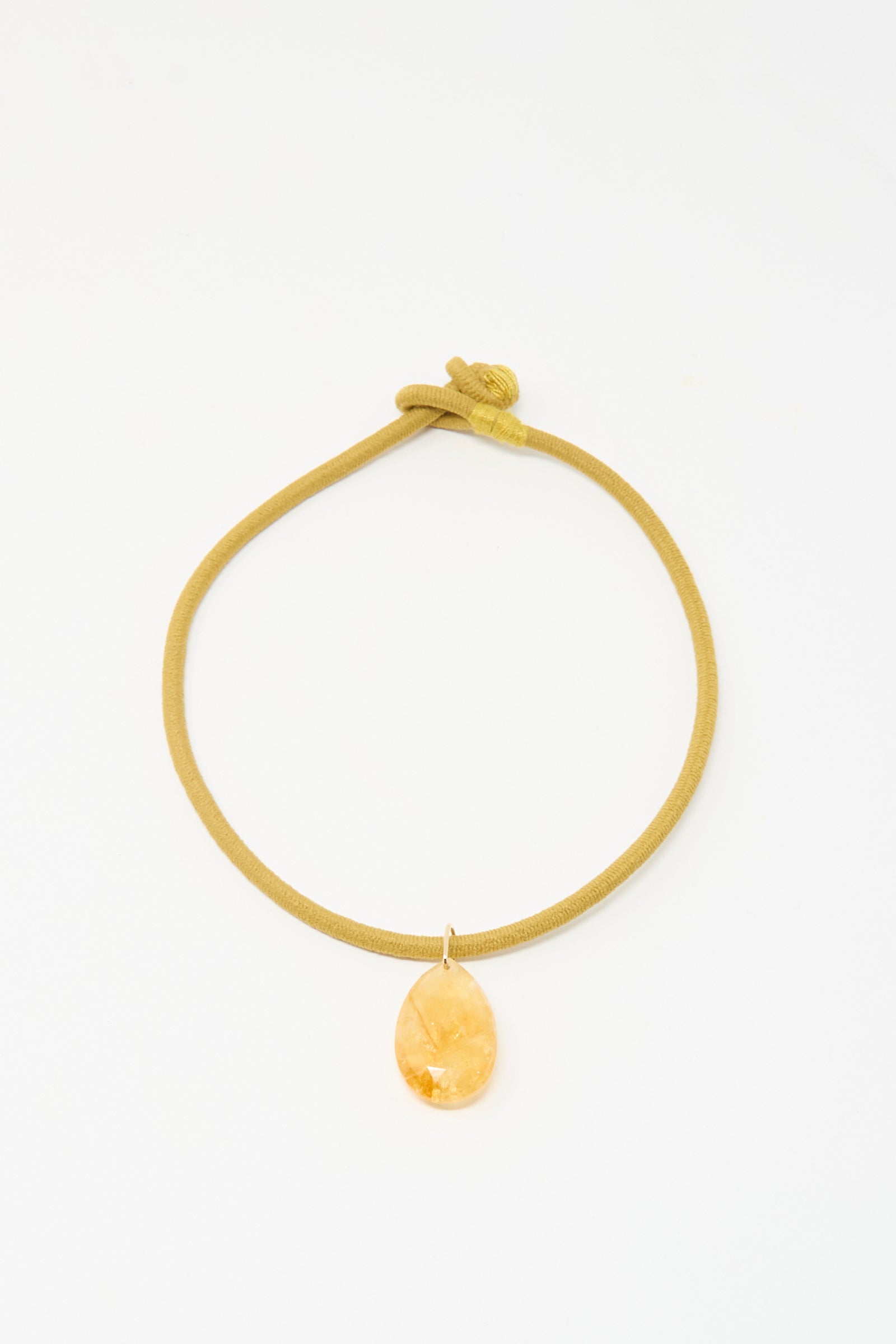 The Drop Cord in Tan and Sunset Citrrine by Laoli features a looped, handmade mustard-yellow cord and a faceted amber teardrop pendant.