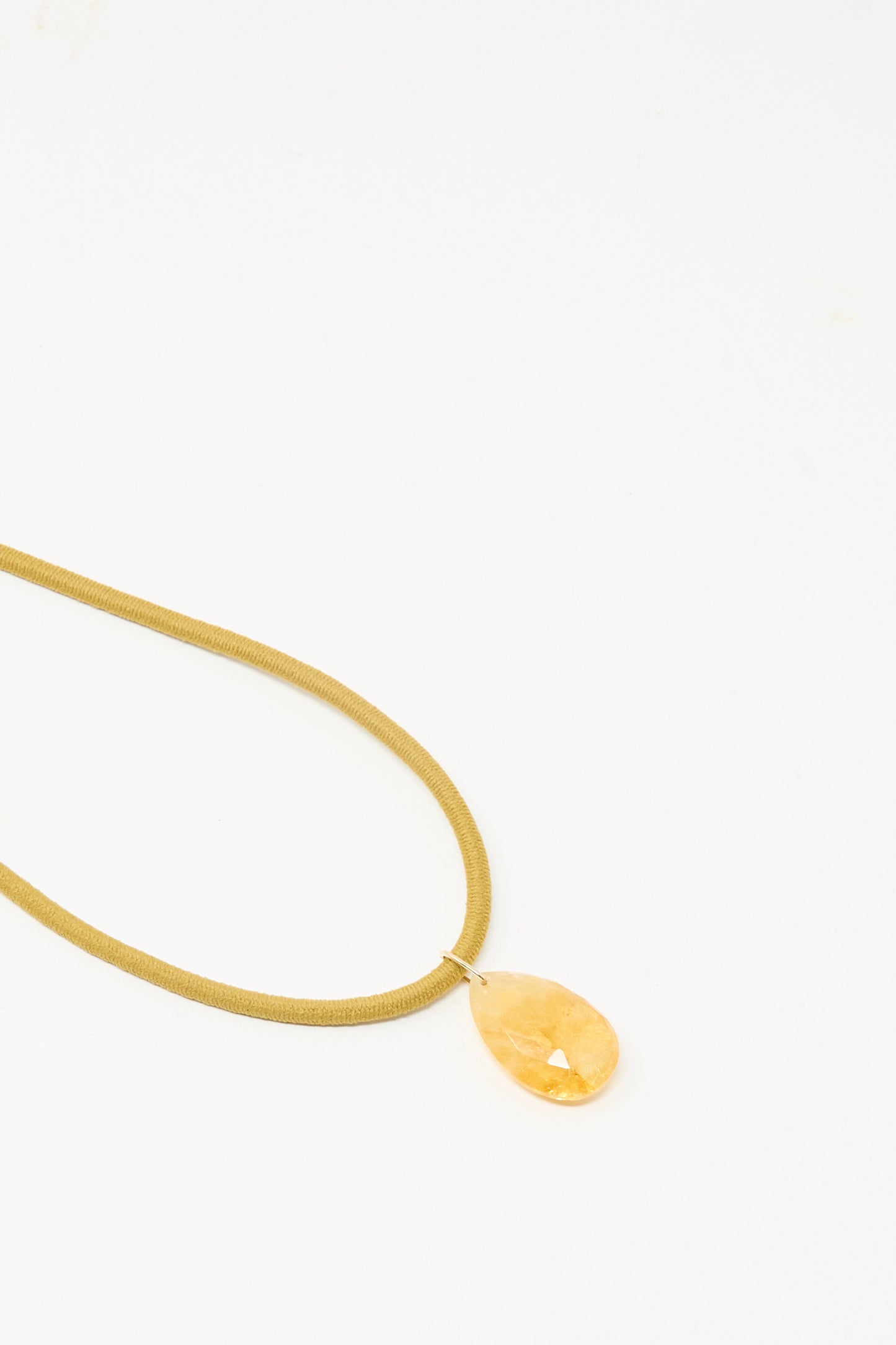 Laoli’s The Drop Cord in Tan and Sunset Citrrine is a handmade necklace with a teardrop-shaped citrine pendant, set in 14k yellow gold and showcased on a plain white background.
