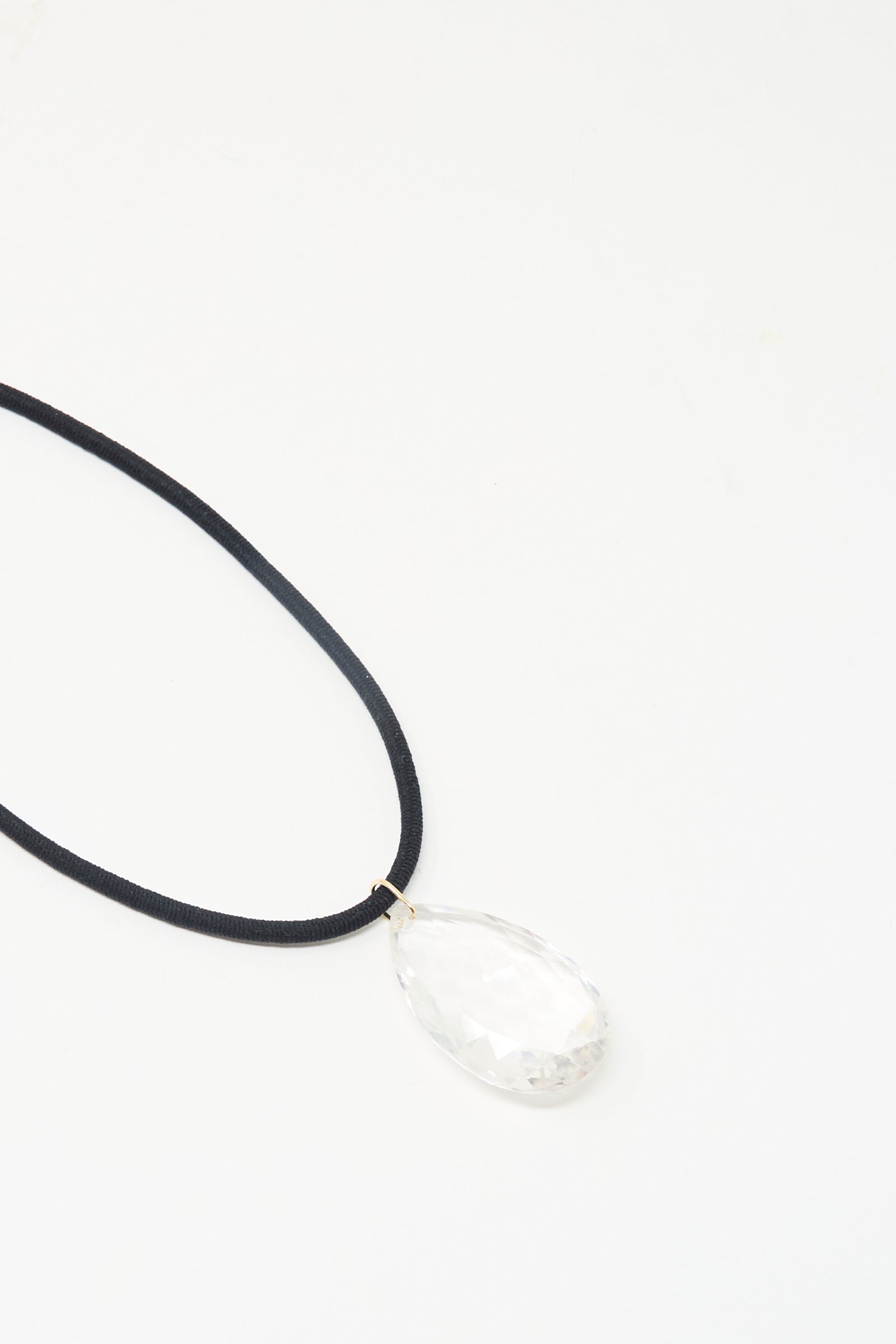 Laoli’s “The Grande Drop in Black Cord and Quartz” features a handmade black cord necklace with a 150-carat clear faceted quartz teardrop pendant, crafted in Paris and shown on a white background.