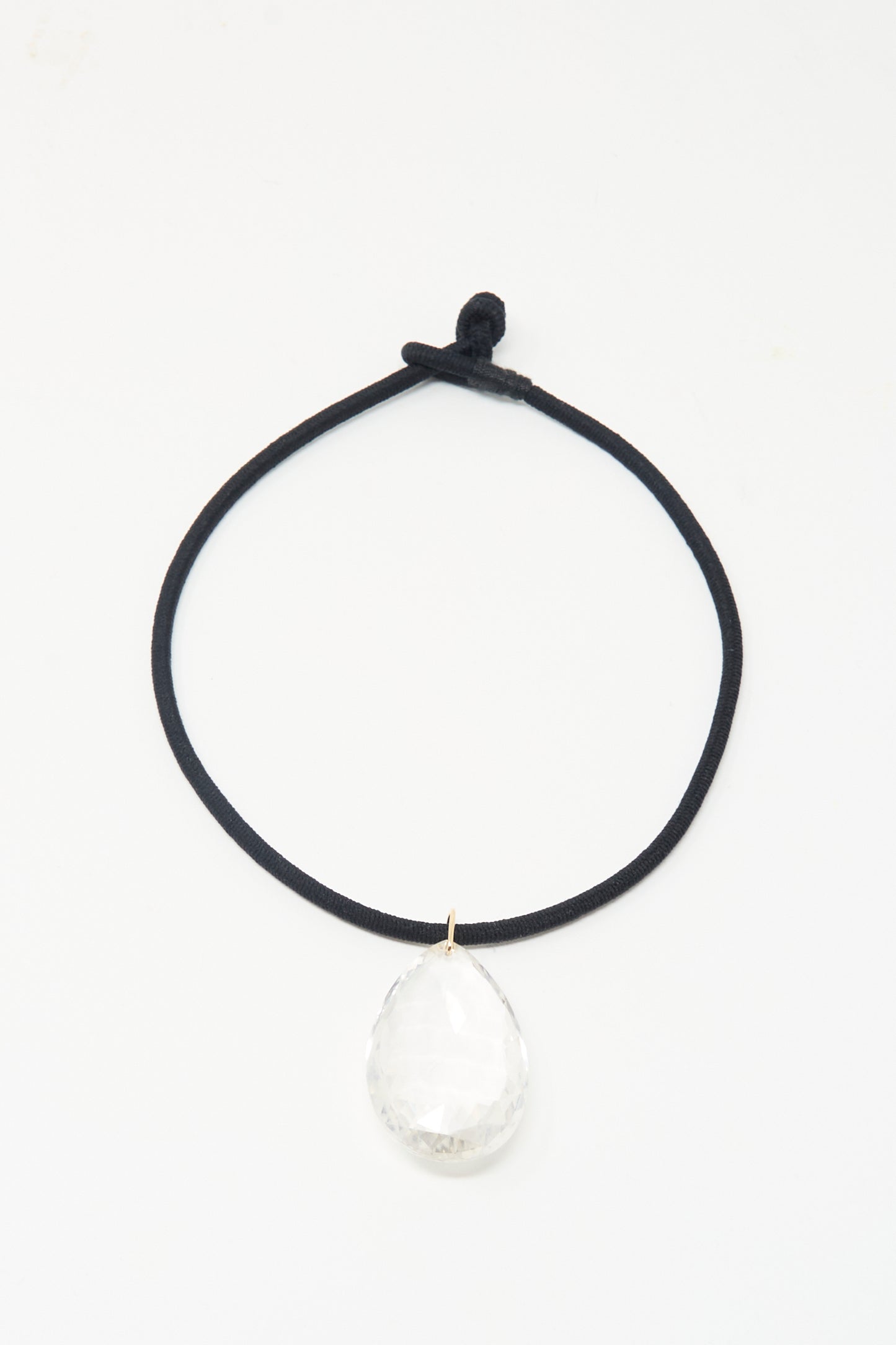 The Grande Drop in Black Cord and Quartz by Laoli: a handmade, 150-carat faceted clear rock crystal teardrop pendant on black cord, shown on a white background.
