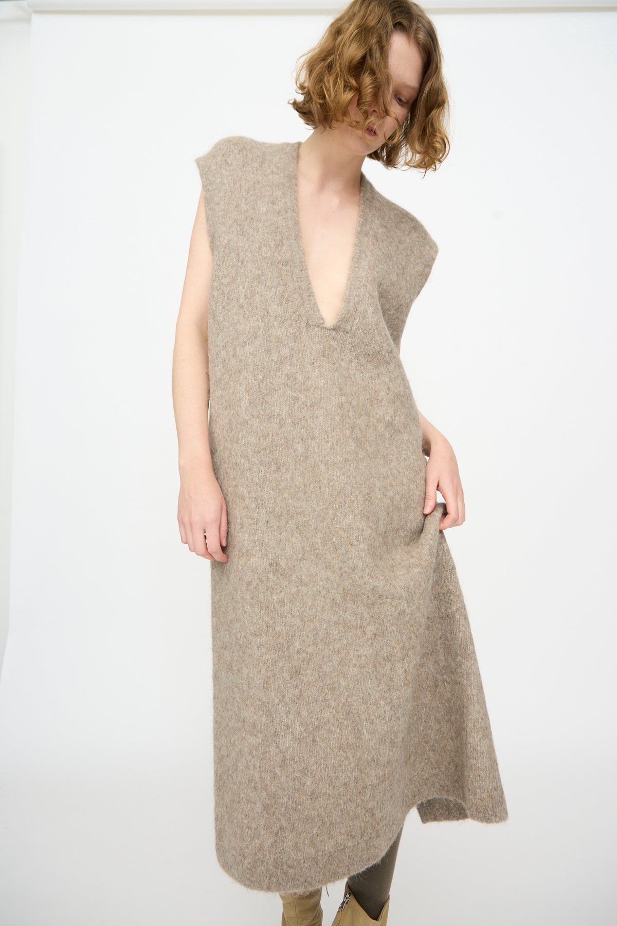 A person wears the Lauren Manoogian Brushed Low V Dress in Grey Melange, a sleeveless knit maxi dress made in Peru, while posing against a plain white background.