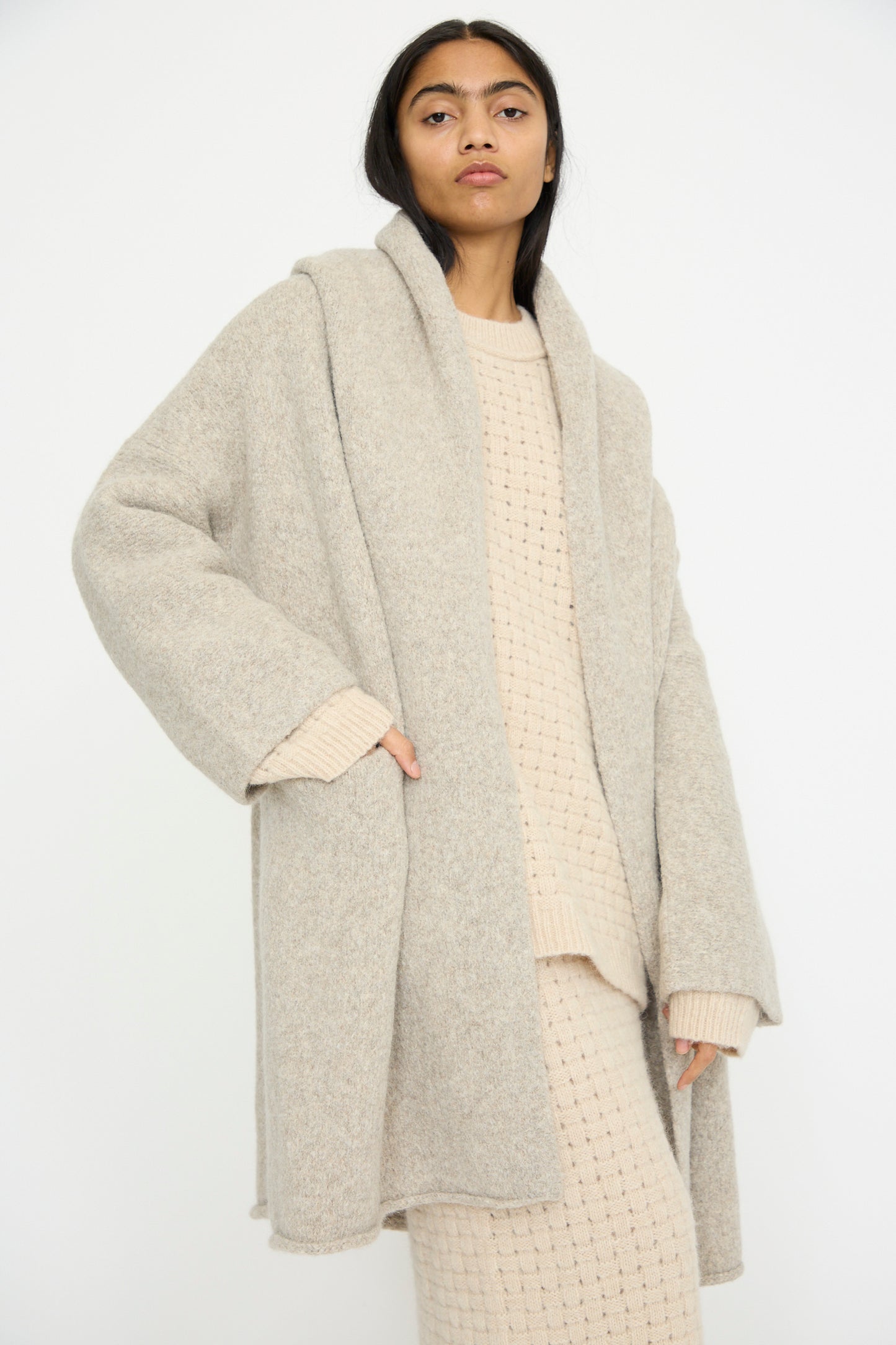 Wearing the relaxed fit Capote Coat in Pebble by Lauren Manoogian, made from soft alpaca wool, a person stands against a plain background. 