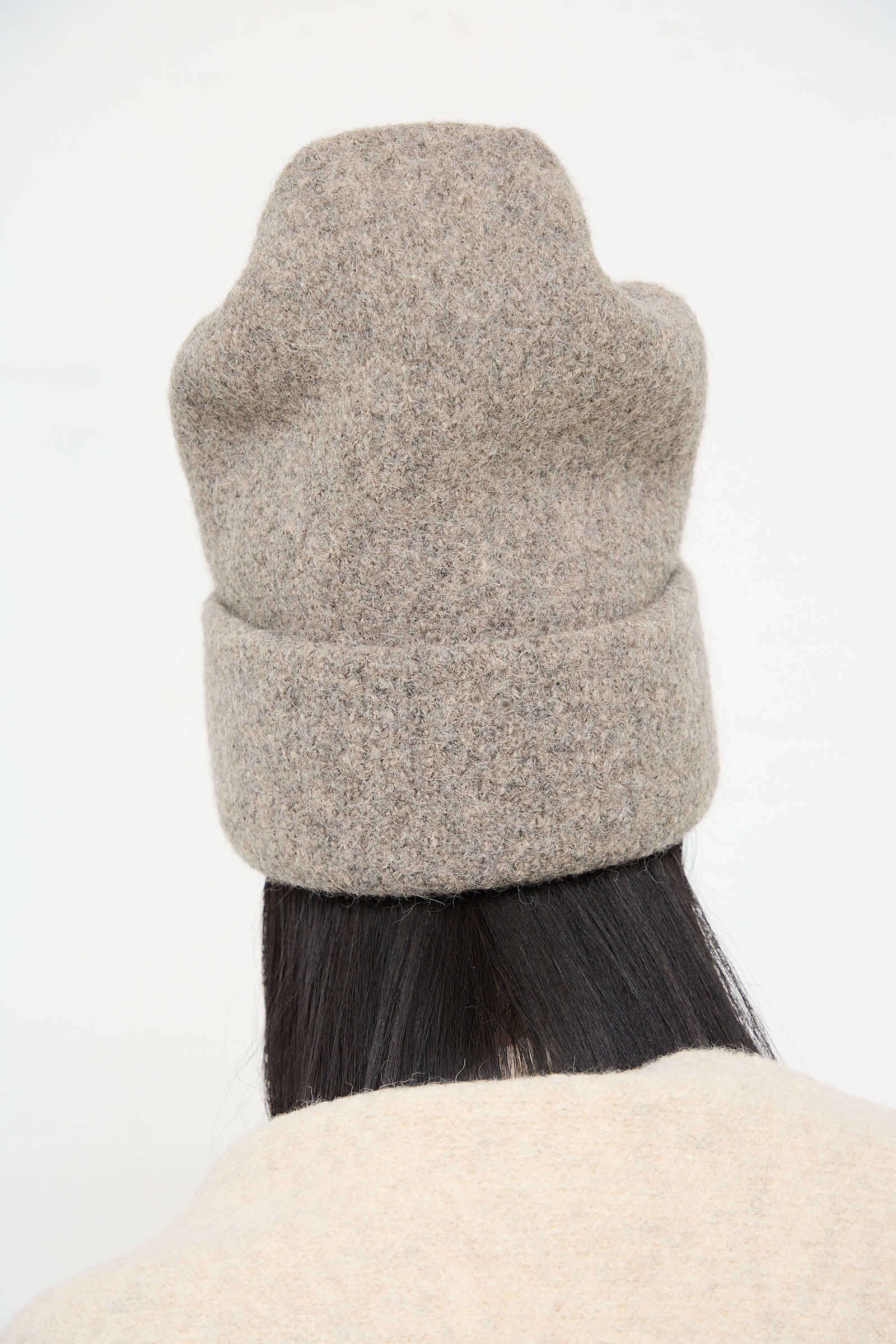 Person wearing a Carpenter Hat in Rock by Lauren Manoogian, made in Peru, viewed from the back, with long black hair visible underneath. The background is plain white.