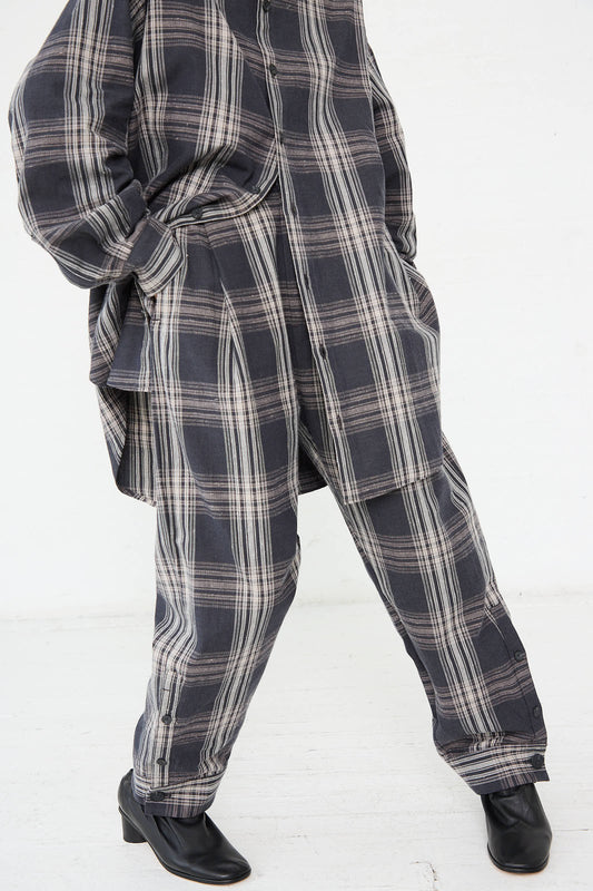 Person dressed in the Lauren Manoogian Cotton Cuff Pant in Plaid paired with a matching cotton plaid shirt and black ankle boots, standing with one leg slightly forward.