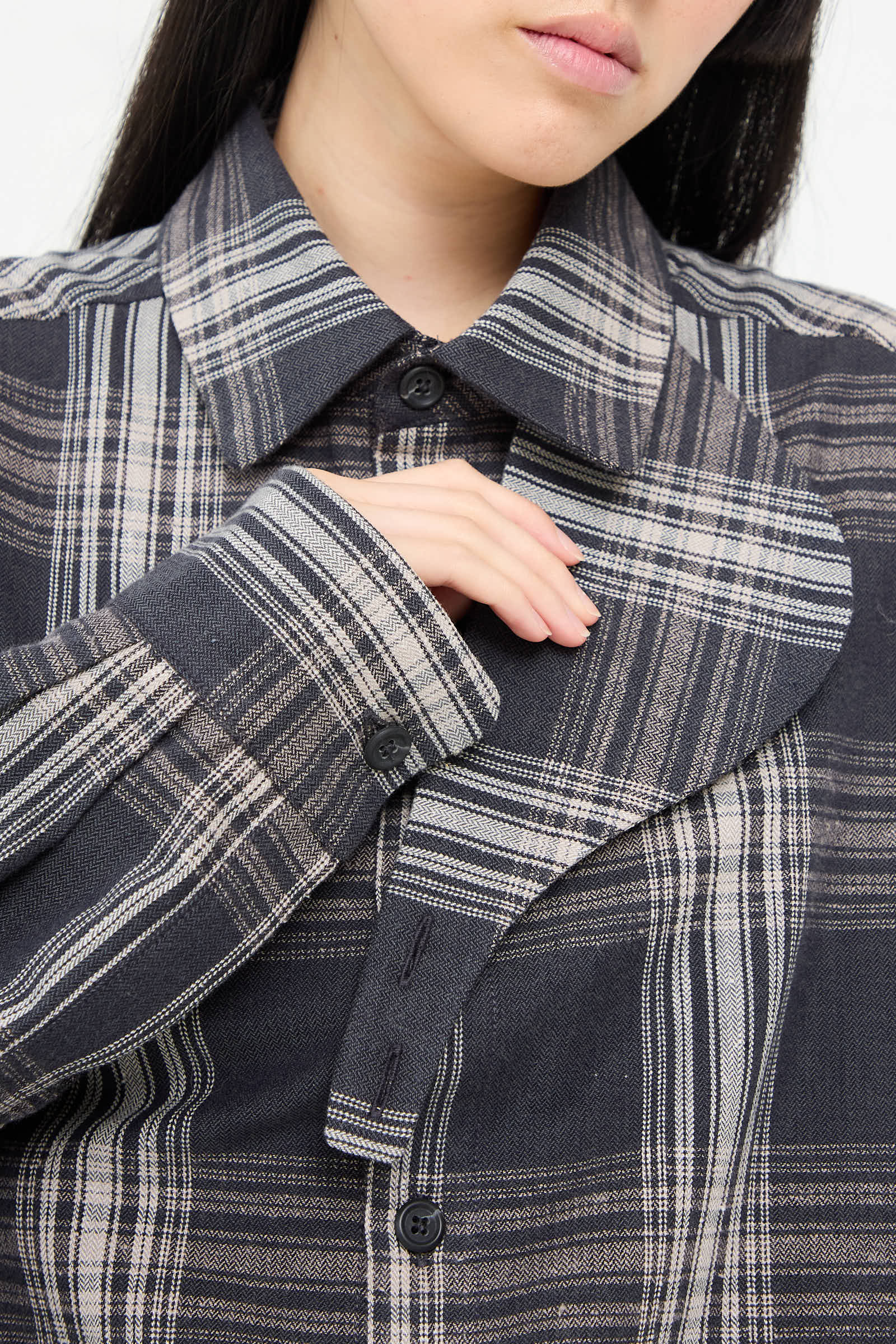 A person wearing the Lauren Manoogian Cotton Gaiter Shirt in Plaid, with a hand adjusting the collar.