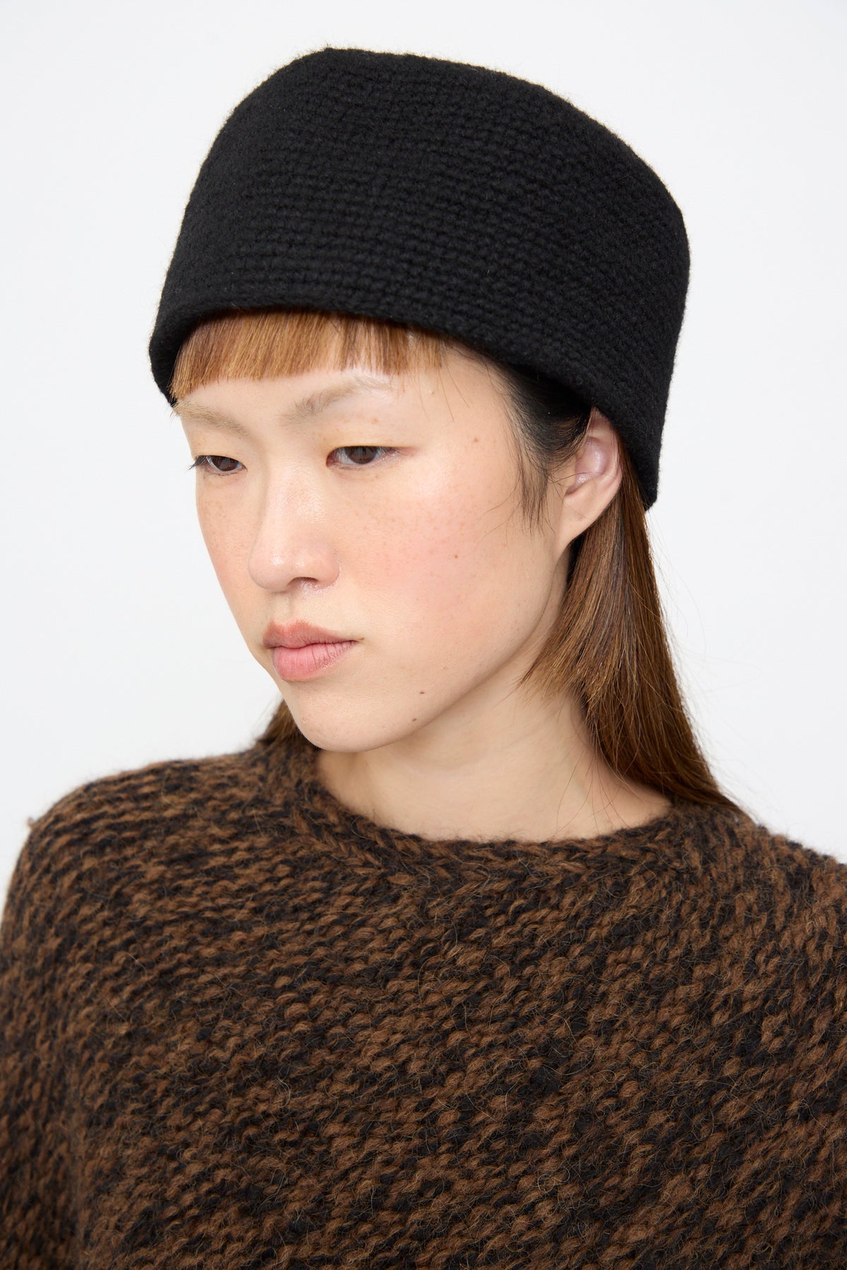 A person wearing a fitted black Lauren Manoogian Crochet Toque in Black.