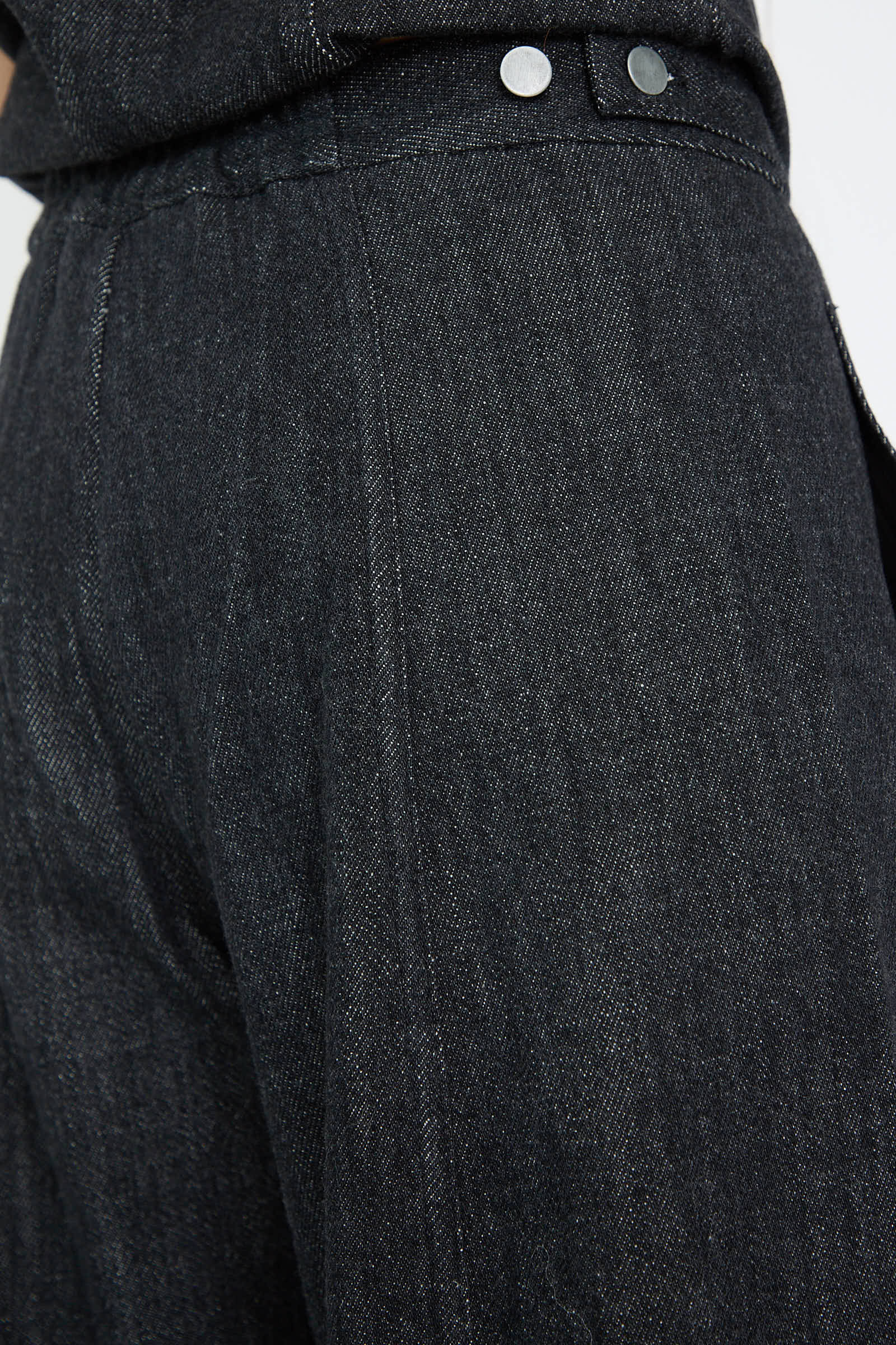 Close-up of the Lauren Manoogian Denim Pant in Indigo, crafted from 100% cotton, featuring silver button details and an adjustable waistband for perfect comfort.