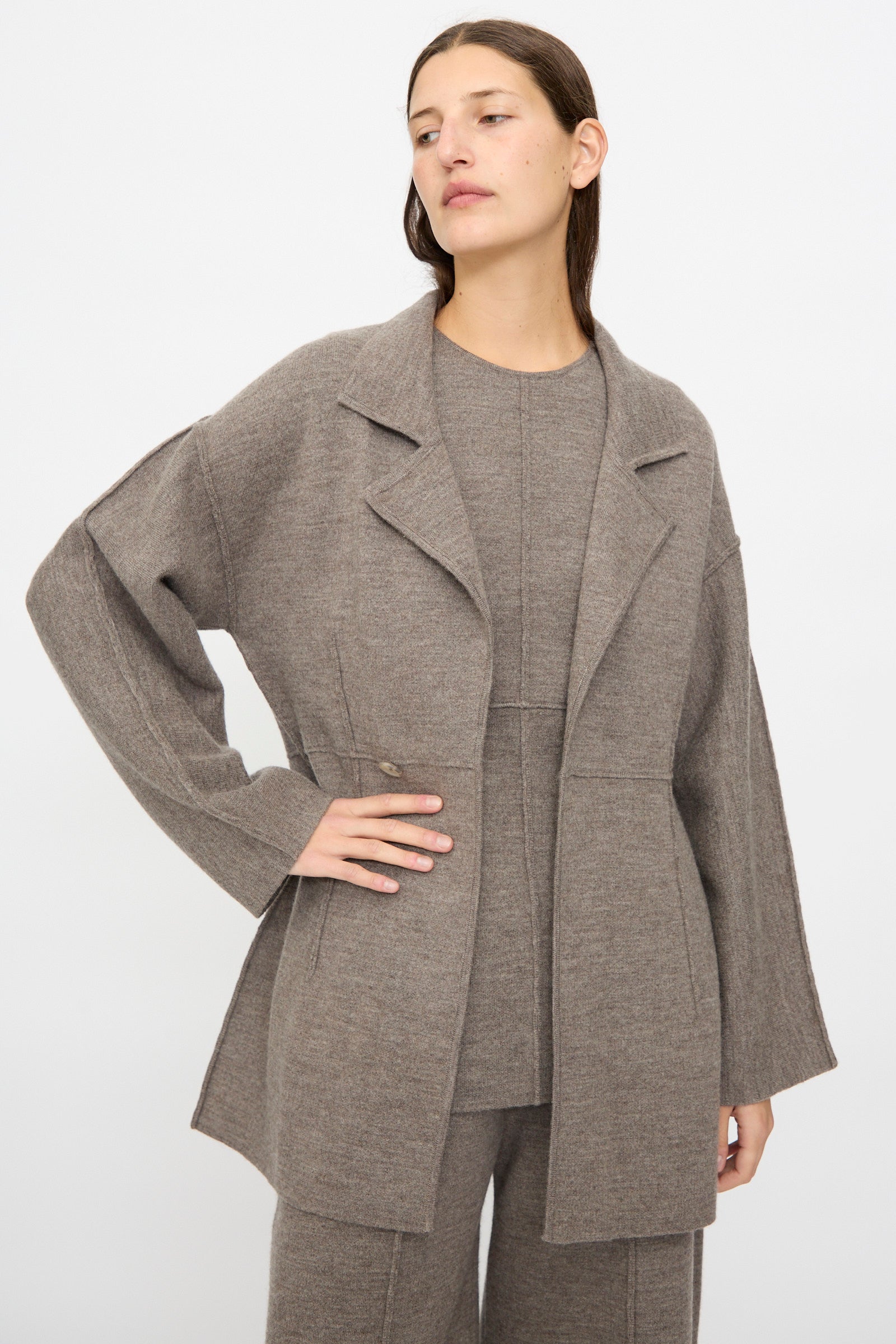 A woman wears the Lauren Manoogian Double Knit Blazer in Cinder over a matching top and pants, standing against a plain light background.