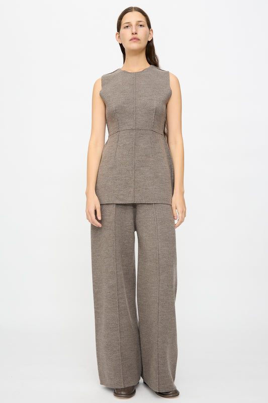 A woman stands facing forward against a plain white background, wearing the Lauren Manoogian Double Knit Trouser in Cinder with visible seam details and a matching sleeveless taupe top.