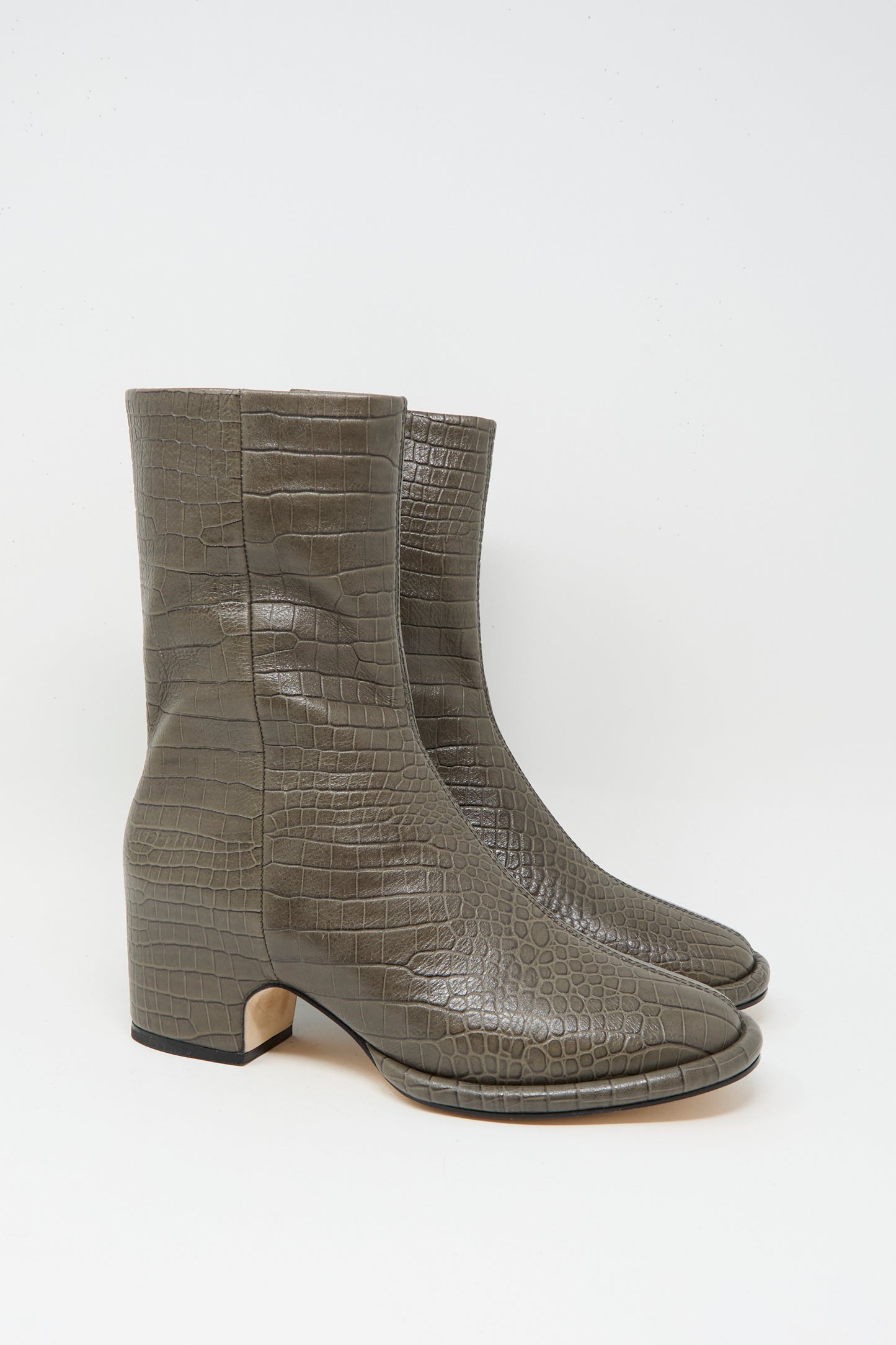 The Embossed Arch Boot in Coal by Lauren Manoogian features gray, above-ankle, crocodile-textured vegetable tanned leather and block heels, shown on a plain white background.