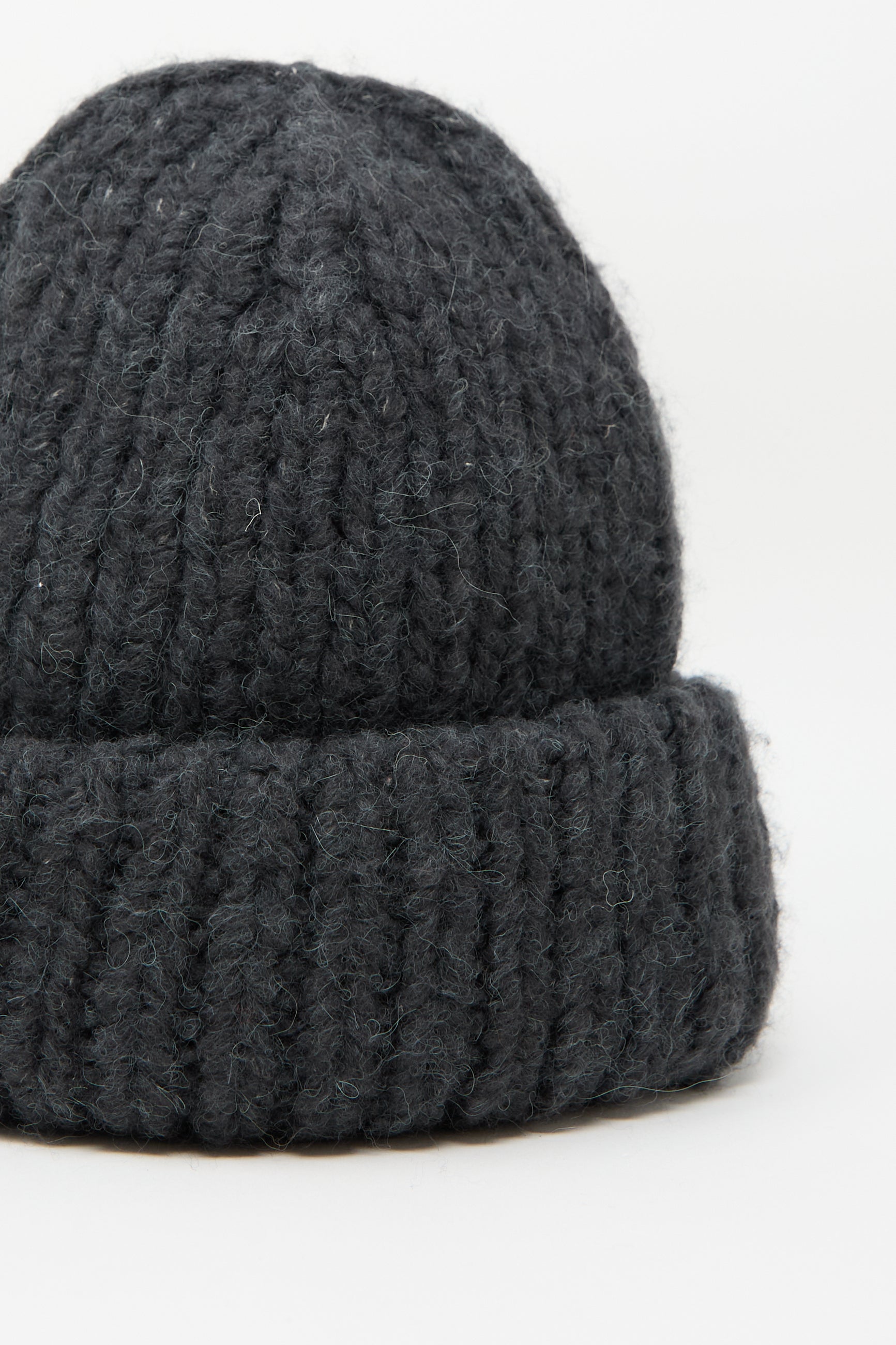 Close-up of the Lauren Manoogian Handknit Big Hat in Ink, showcasing a thick, ribbed texture. Crafted in Peru from an alpaca/wool blend for superior warmth and comfort.