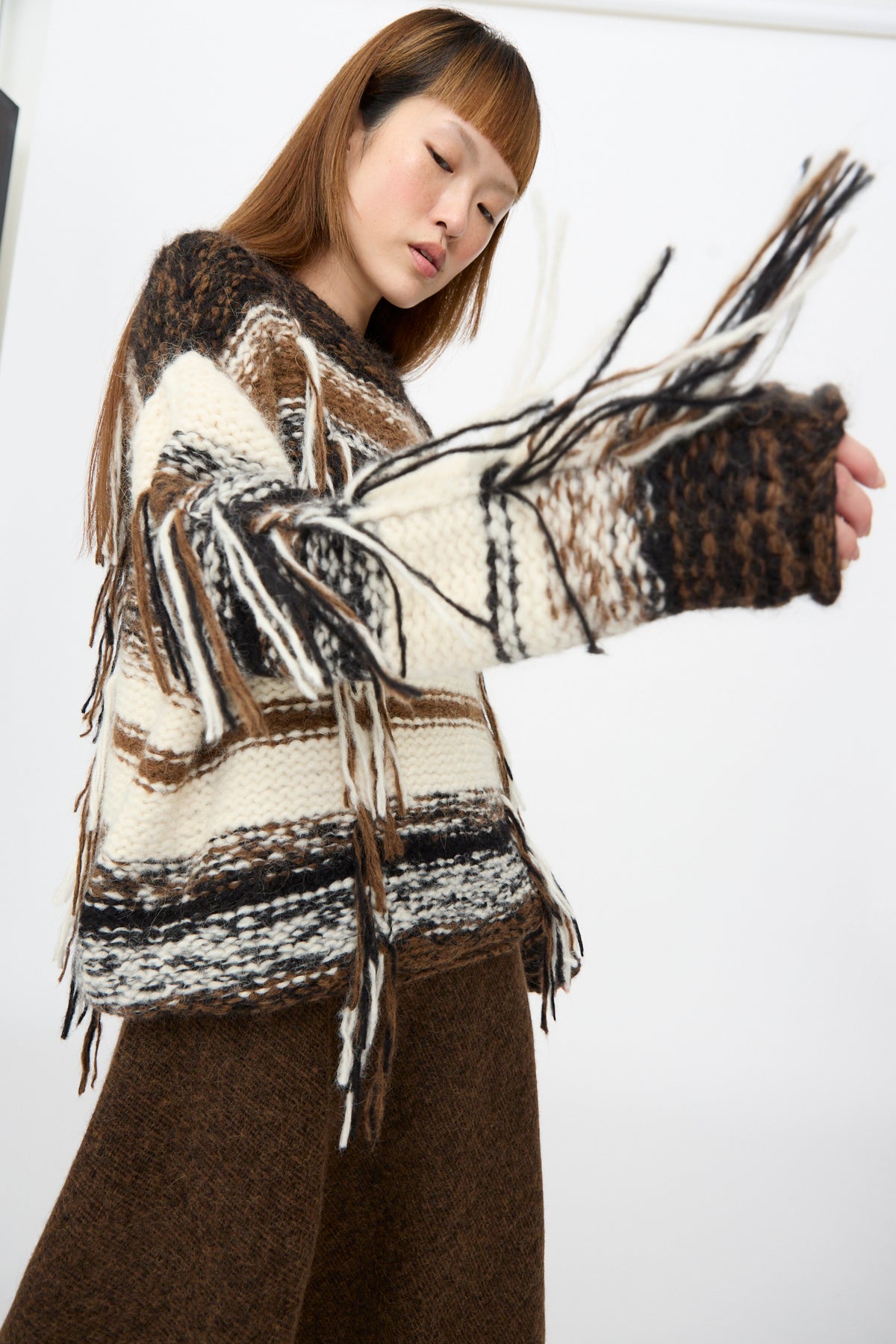 Lauren Manoogian Handknit Rio Rollneck in Marl Stripe, an oversized, chunky striped sweater featuring fringe details on the sleeves.