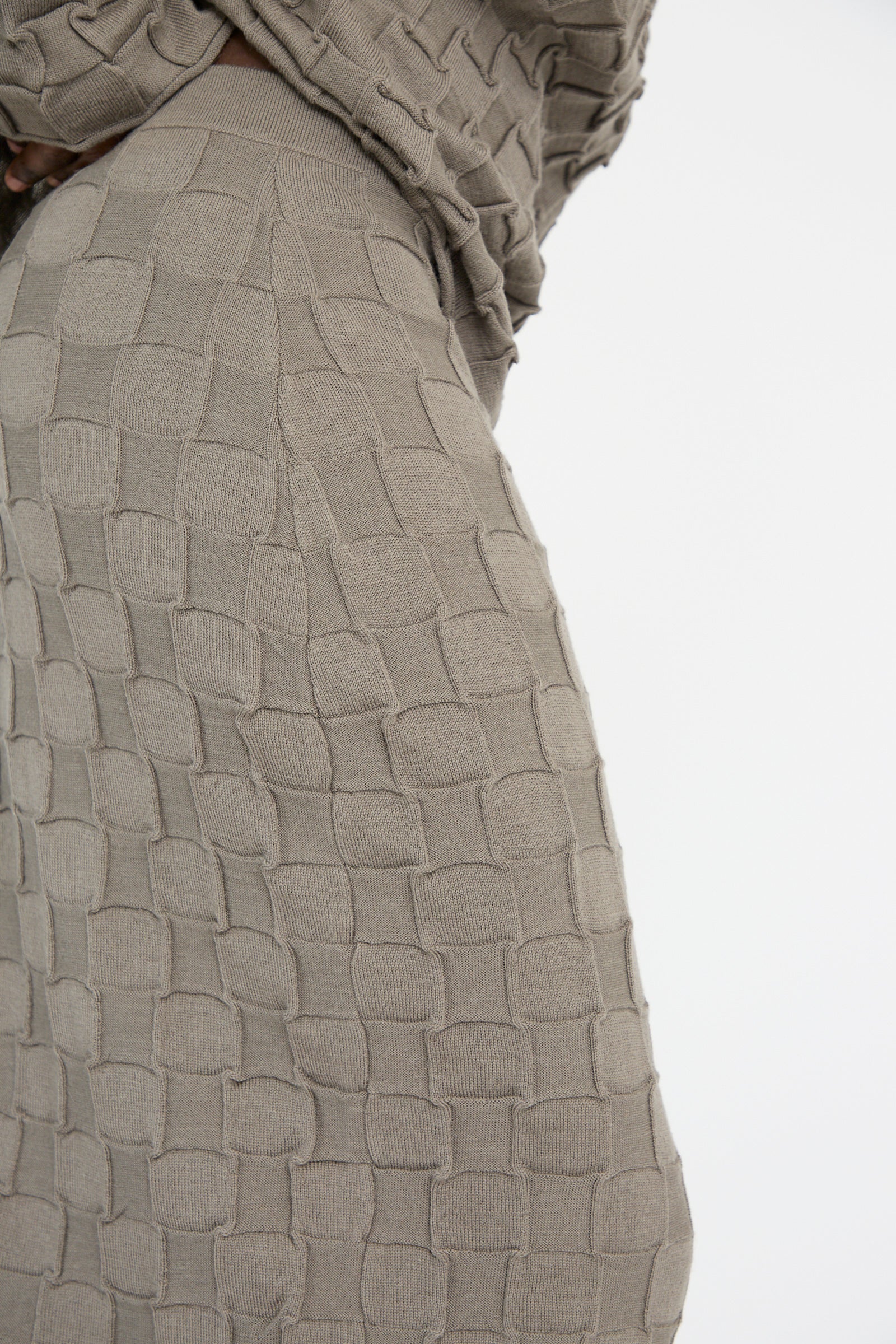 Close-up of a square-patterned, textured fabric in beige crafted from soft merino wool, featured in the Inlay Skirt in Concrete by Lauren Manoogian.