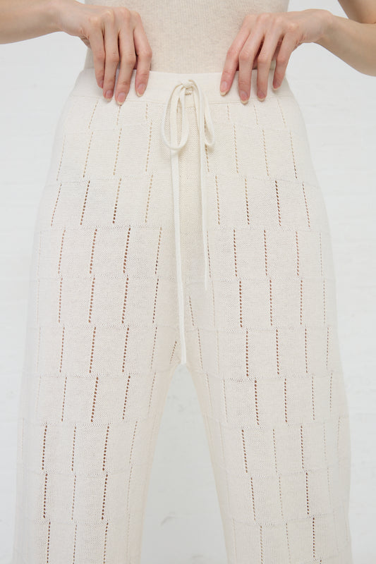 Close-up of a person wearing Lauren Manoogian's Lattice Pant in Bone with a textured pattern.