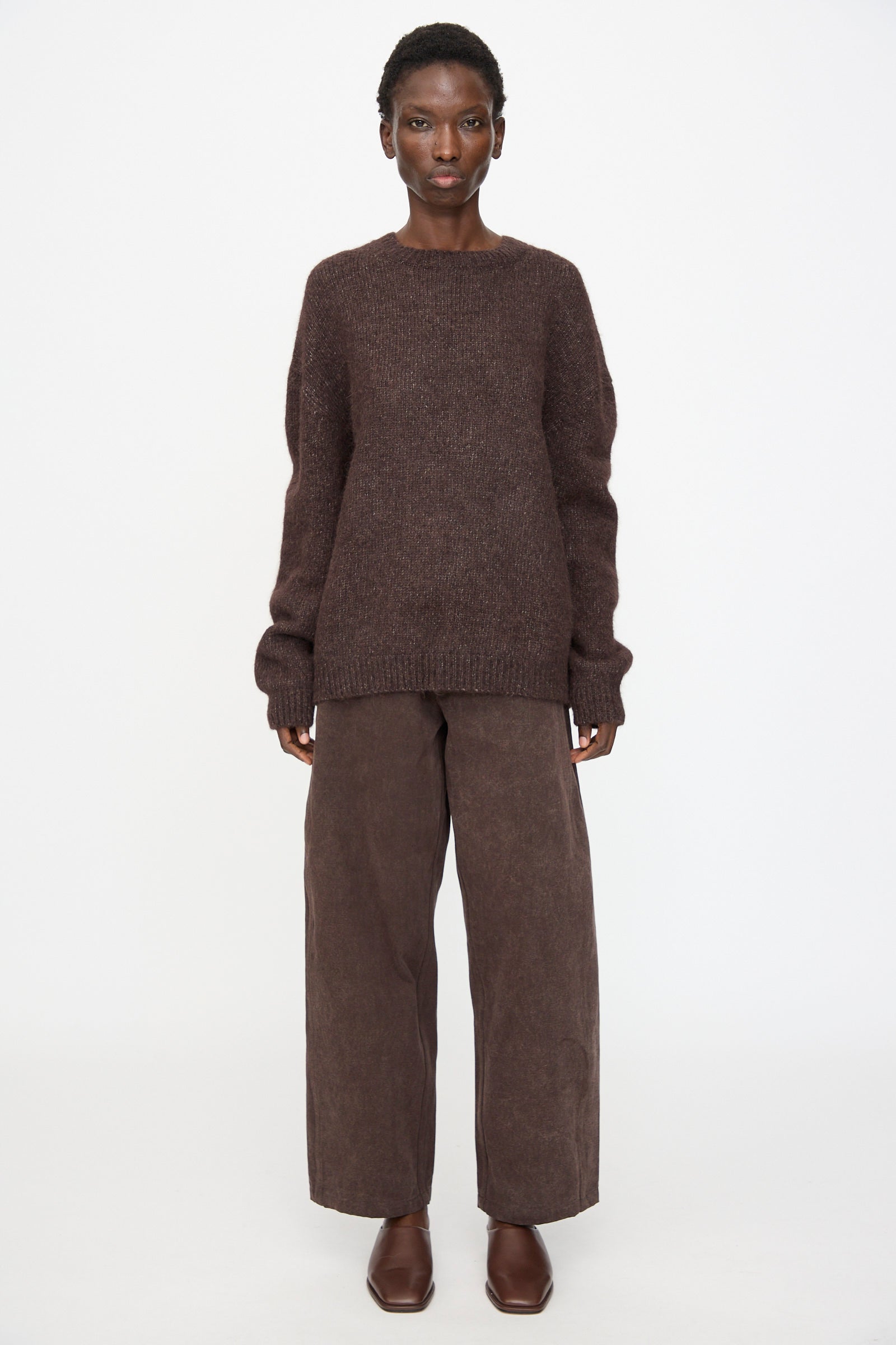 A person faces forward wearing the Lauren Manoogian Loft Crewneck in Soil with matching wide-leg brown pants and brown shoes, set against a plain white background.