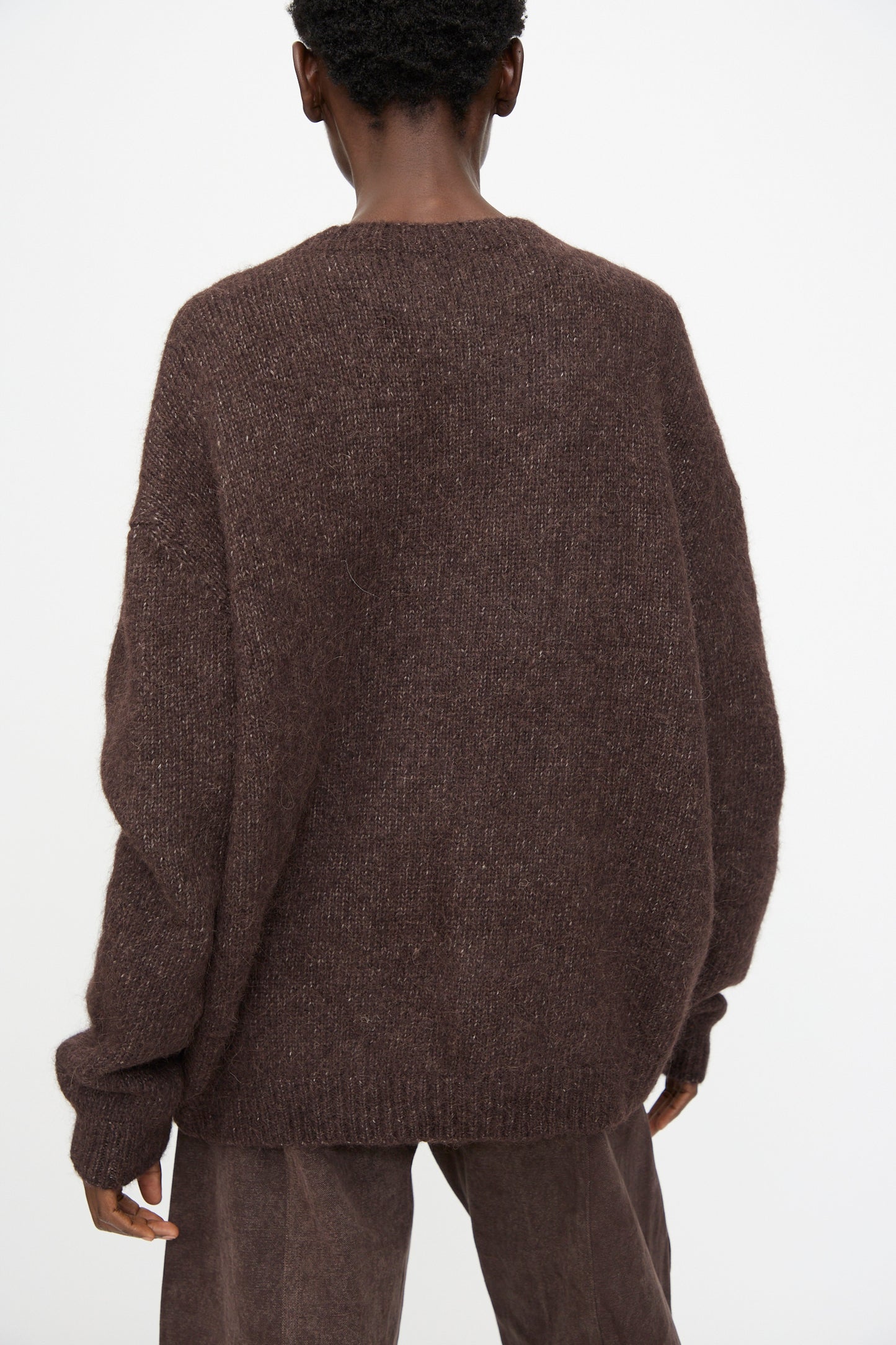 Model wears the Lauren Manoogian Loft Crewneck in Soil with matching brown pants, shown from the back against a plain white background.