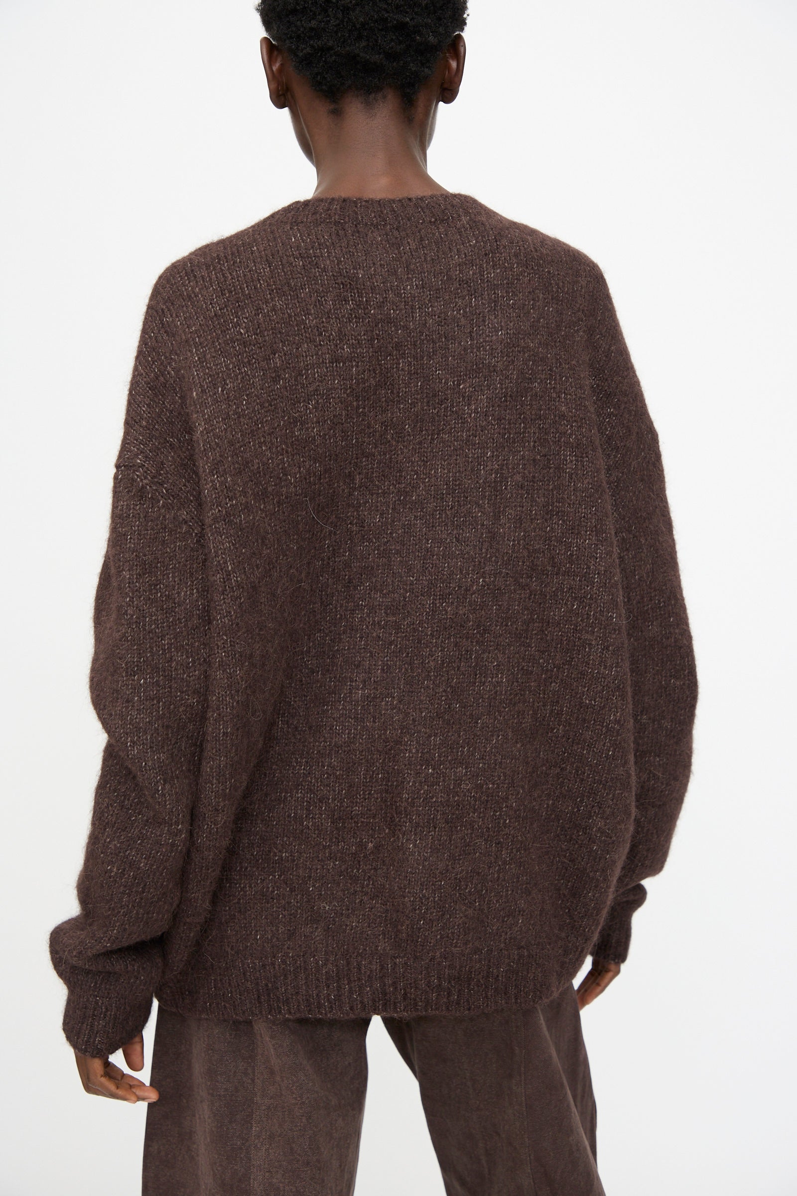 Model wears the Lauren Manoogian Loft Crewneck in Soil with matching brown pants, shown from the back against a plain white background.