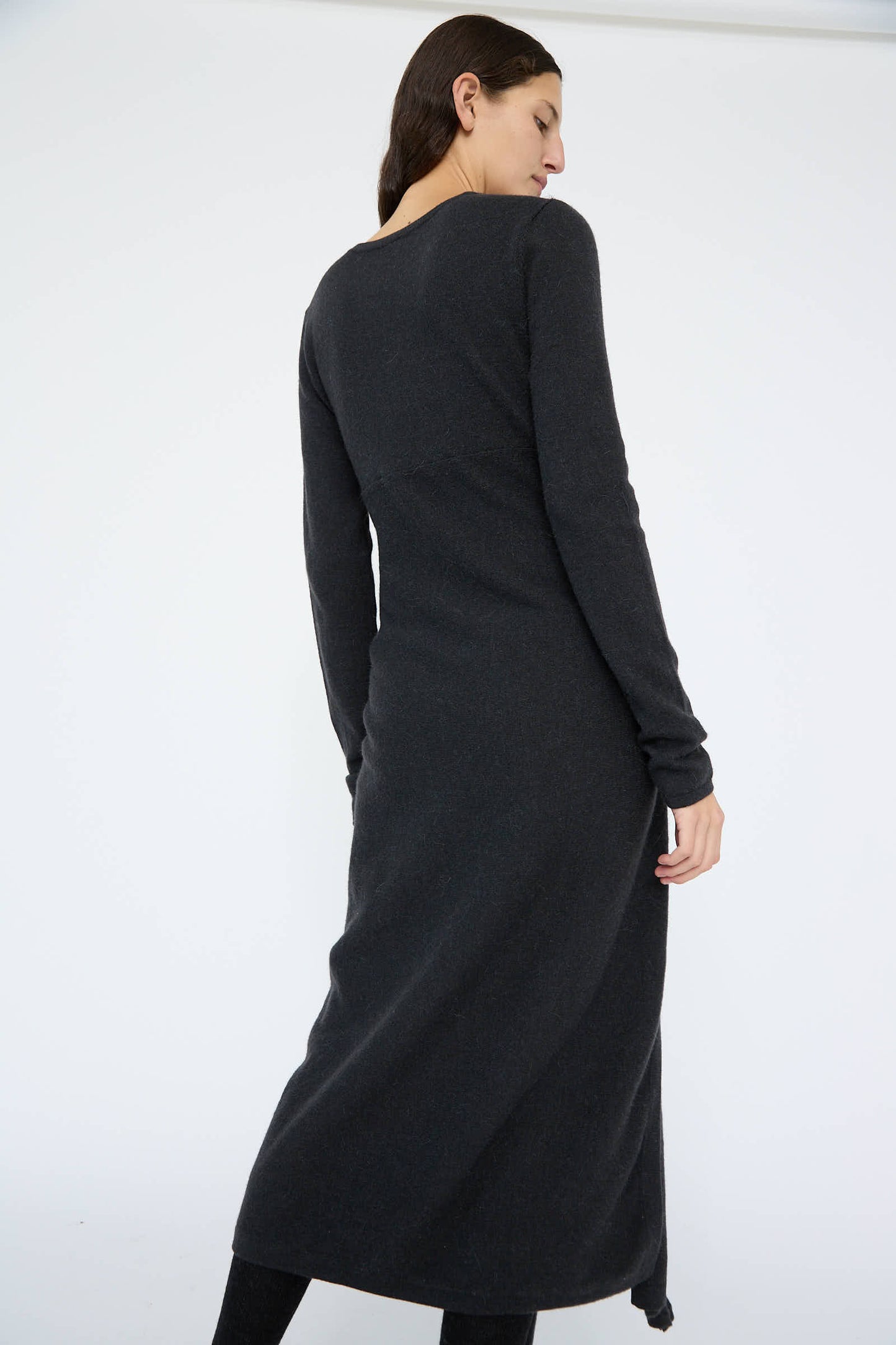 A person wearing the Sleeves Dress in Ink by Lauren Manoogian stands against a white background, facing away. The relaxed fit and wool/alpaca blend of the dress add an elegant touch to their silhouette.