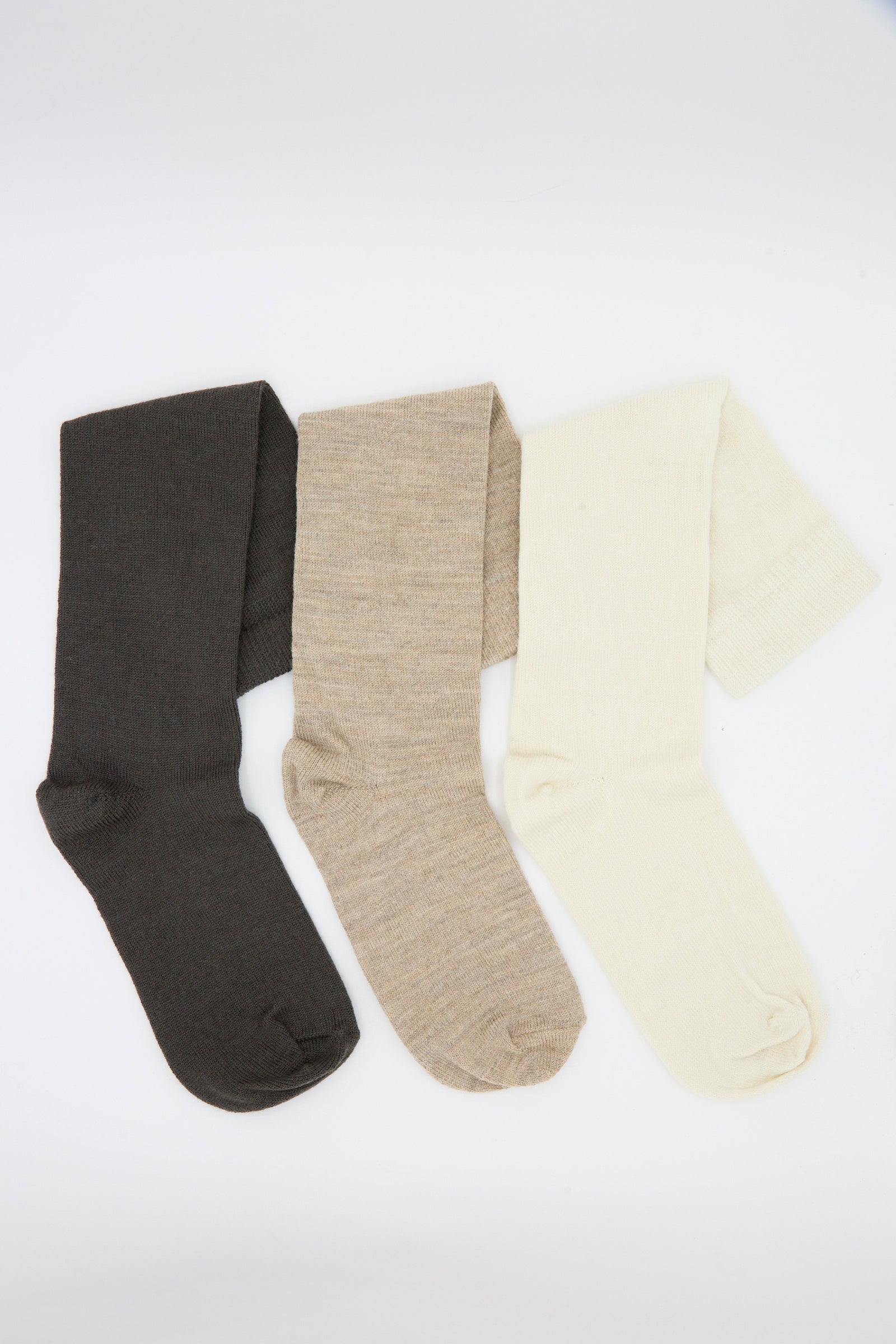Three pairs of Lauren Manoogian’s Sock Set in Mix, featuring dark brown, light brown, and off-white alpaca wool socks, are arranged side by side on a white background.