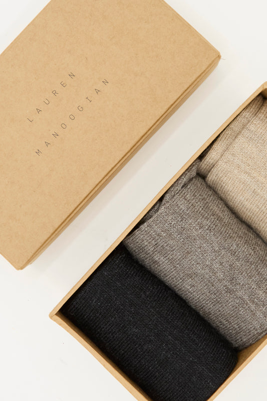 The Lauren Manoogian Sock Set in Mix includes three pairs of luxurious alpaca wool mid-calf socks in black, gray, and beige, all made in Peru.