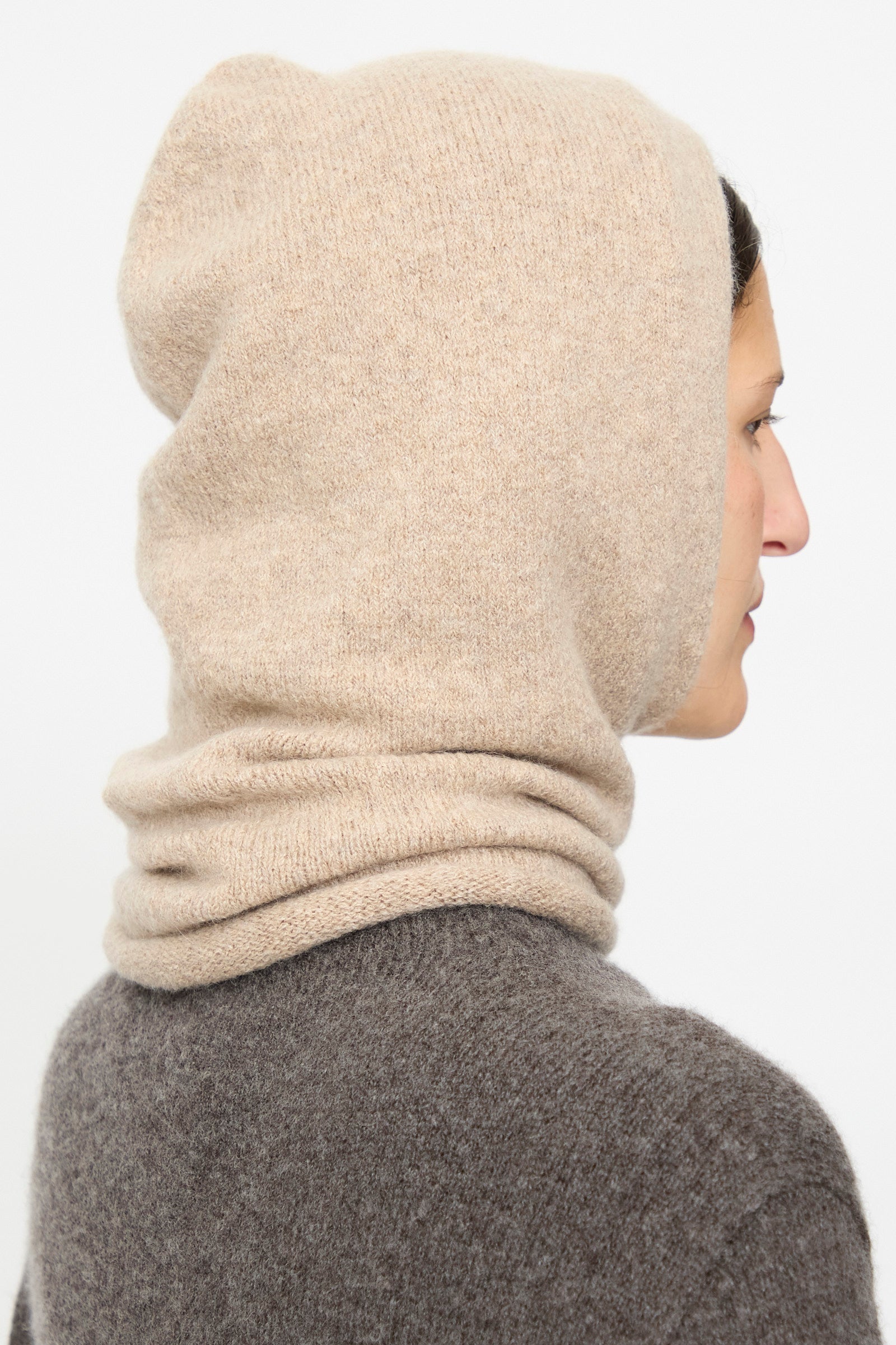 Person in profile wearing the Lauren Manoogian Soft Balaclava in Oak and a brown sweater, facing right against a plain white background.