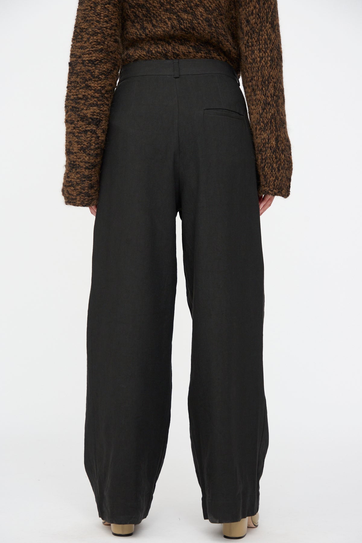 Back view of a person wearing black Soft Trouser by Lauren Manoogian and a brown textured sweater.