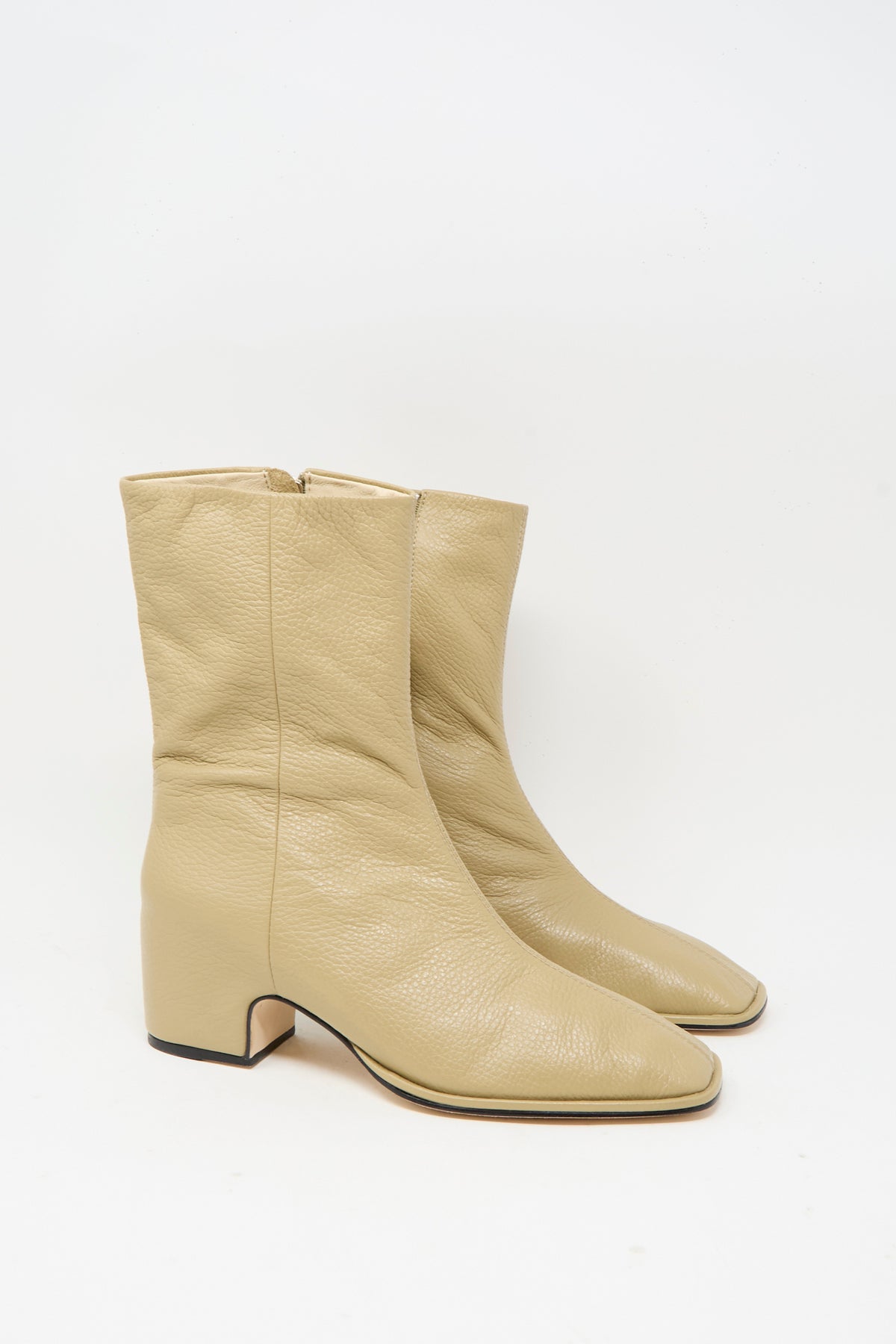 The Square Arch Boot in Beige by Lauren Manoogian is a pair of mid-calf boots made from vegetable tanned leather, featuring a square toe, block heel, and durable leather sole, shown against a white background.