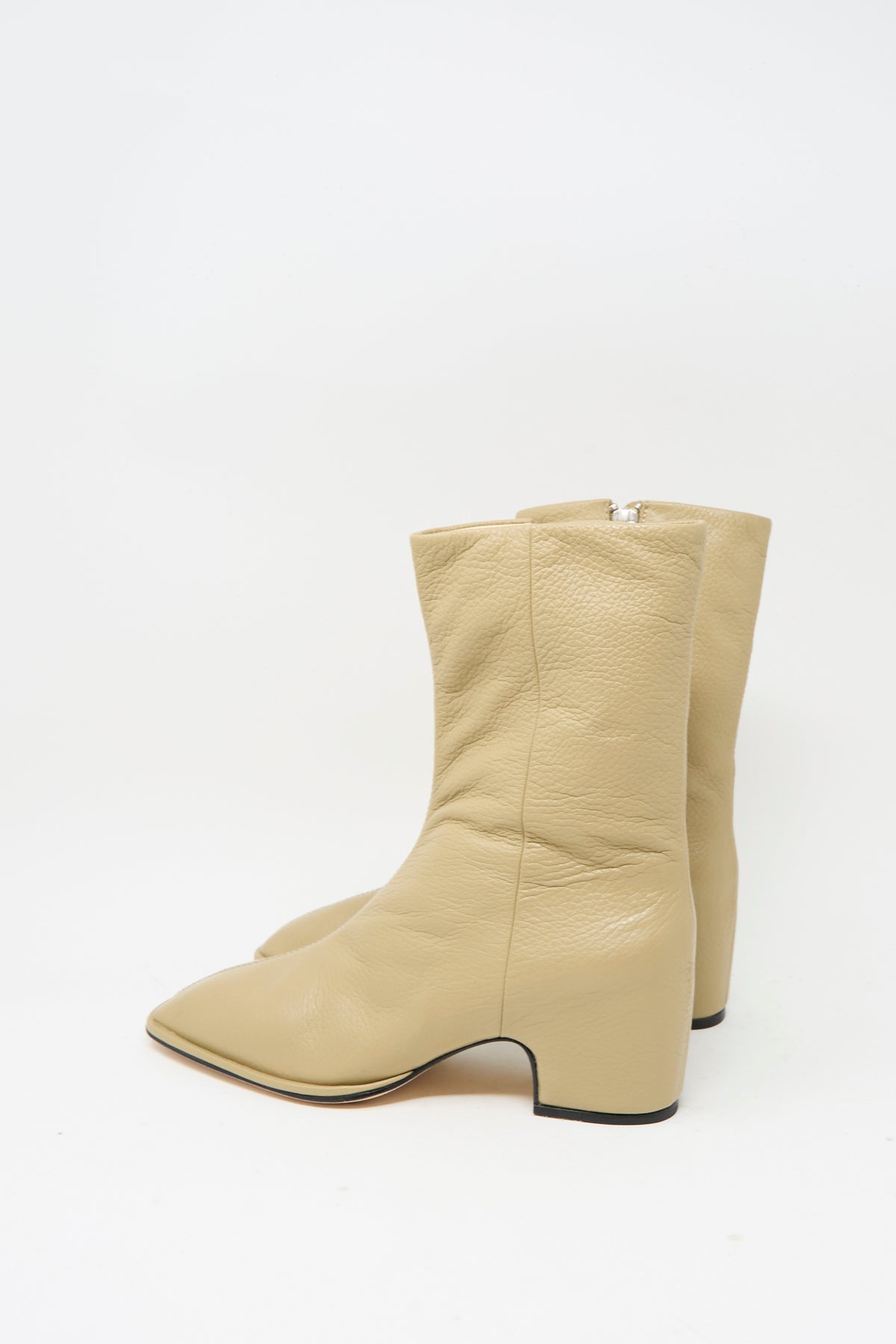 A pair of Lauren Manoogian Square Arch Boots in beige, crafted from vegetable-tanned leather with mid-calf height, low block heels, side zippers, and a sturdy leather sole, displayed against a plain white background.