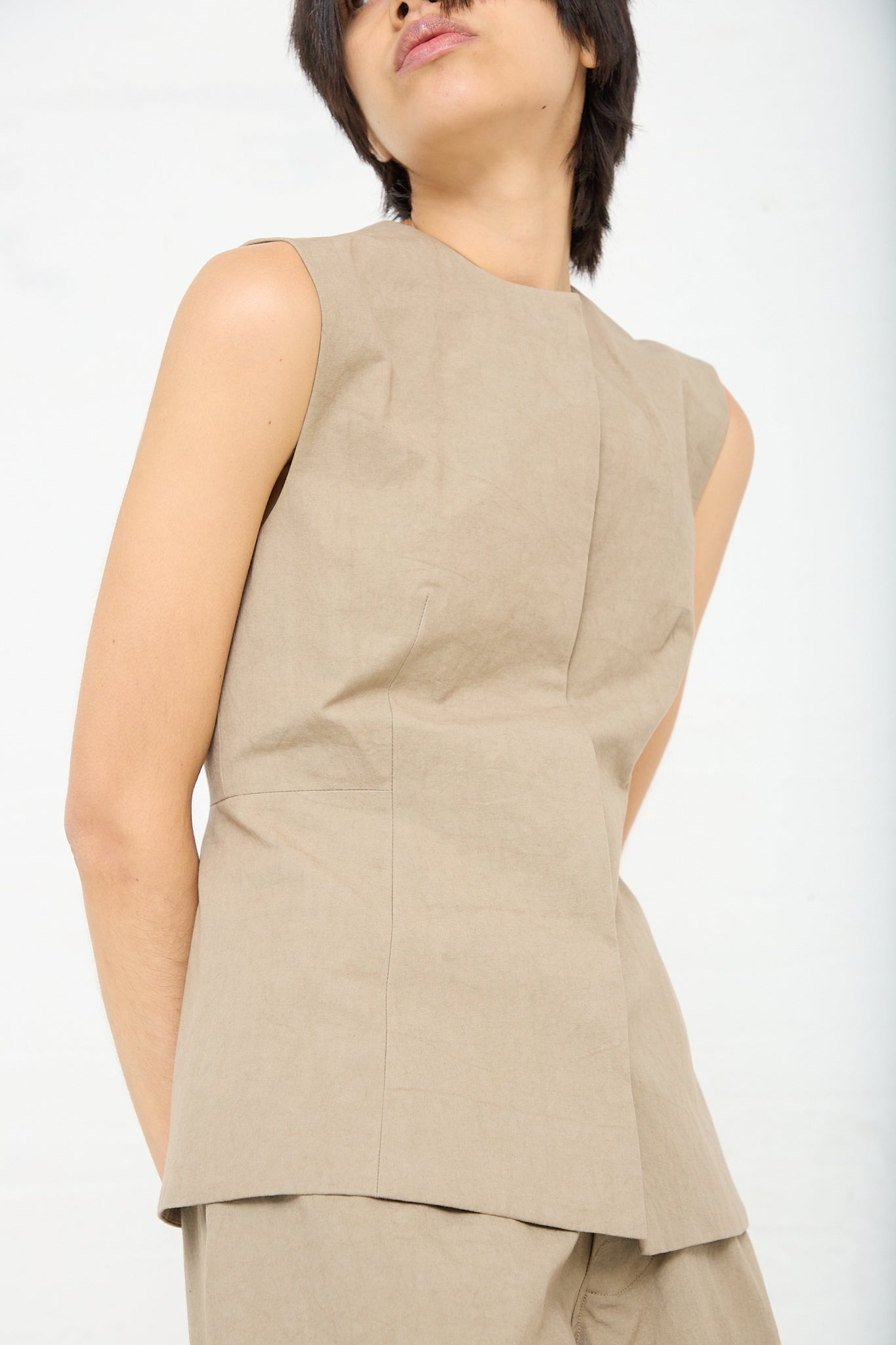 A woman wearing a Sleeveless Structure Bodice in Drab (Olive Brown) cotton by Lauren Manoogian.