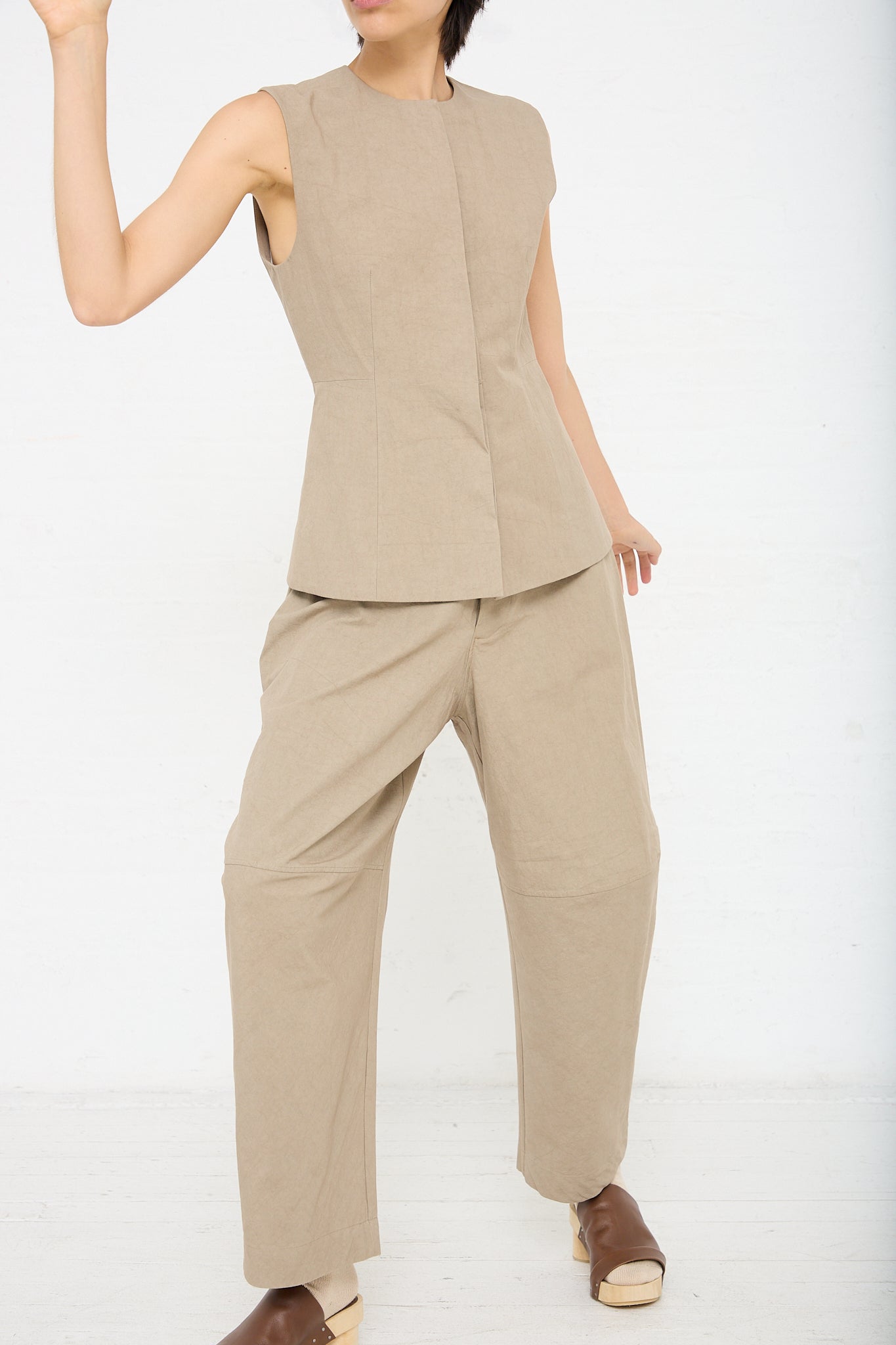 A woman wearing a sleeveless Structure Bodice in Drab (Olive Brown) jumpsuit made of cotton and sandals.