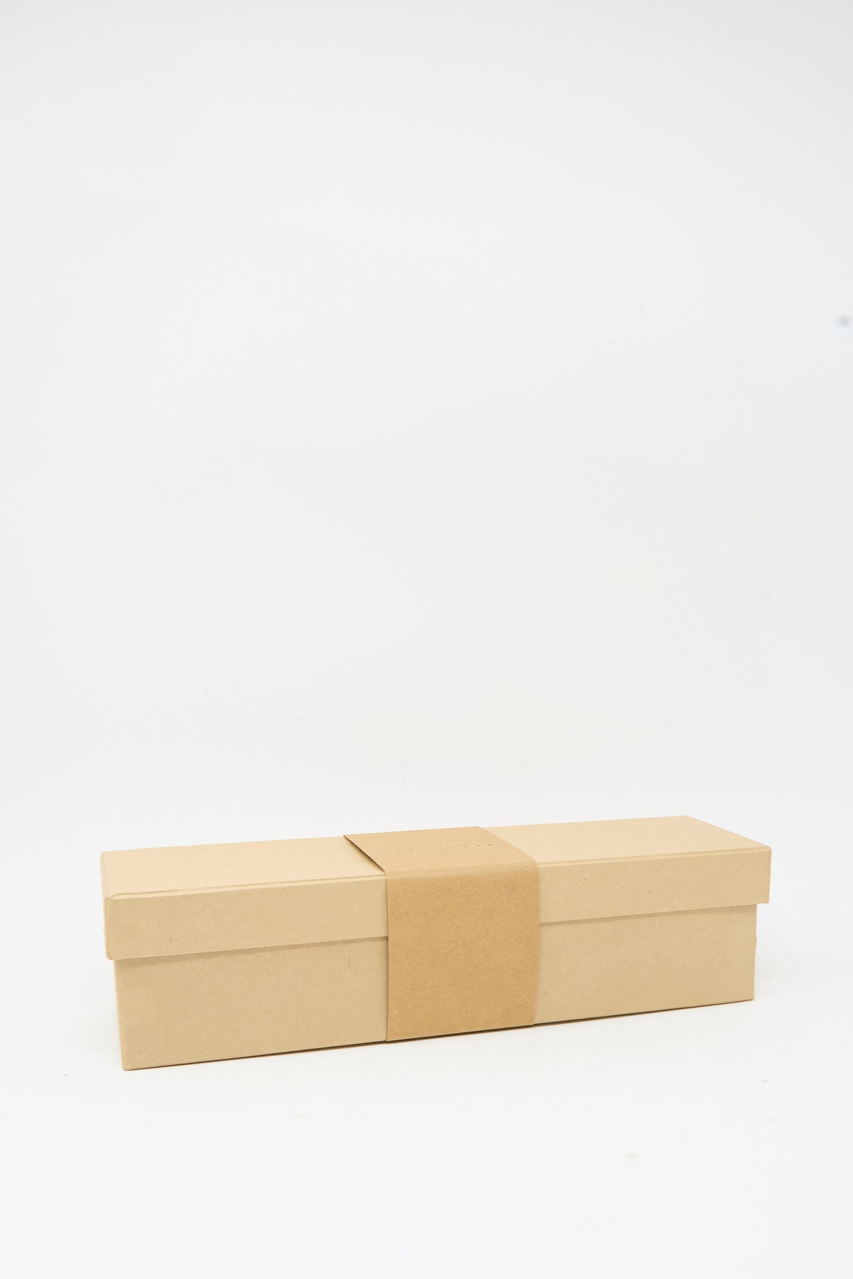 A rectangular, closed cardboard box with a paper sleeve, featuring the Lauren Manoogian Tall Sock Set in Mix and made in Peru, is placed on a plain white background.