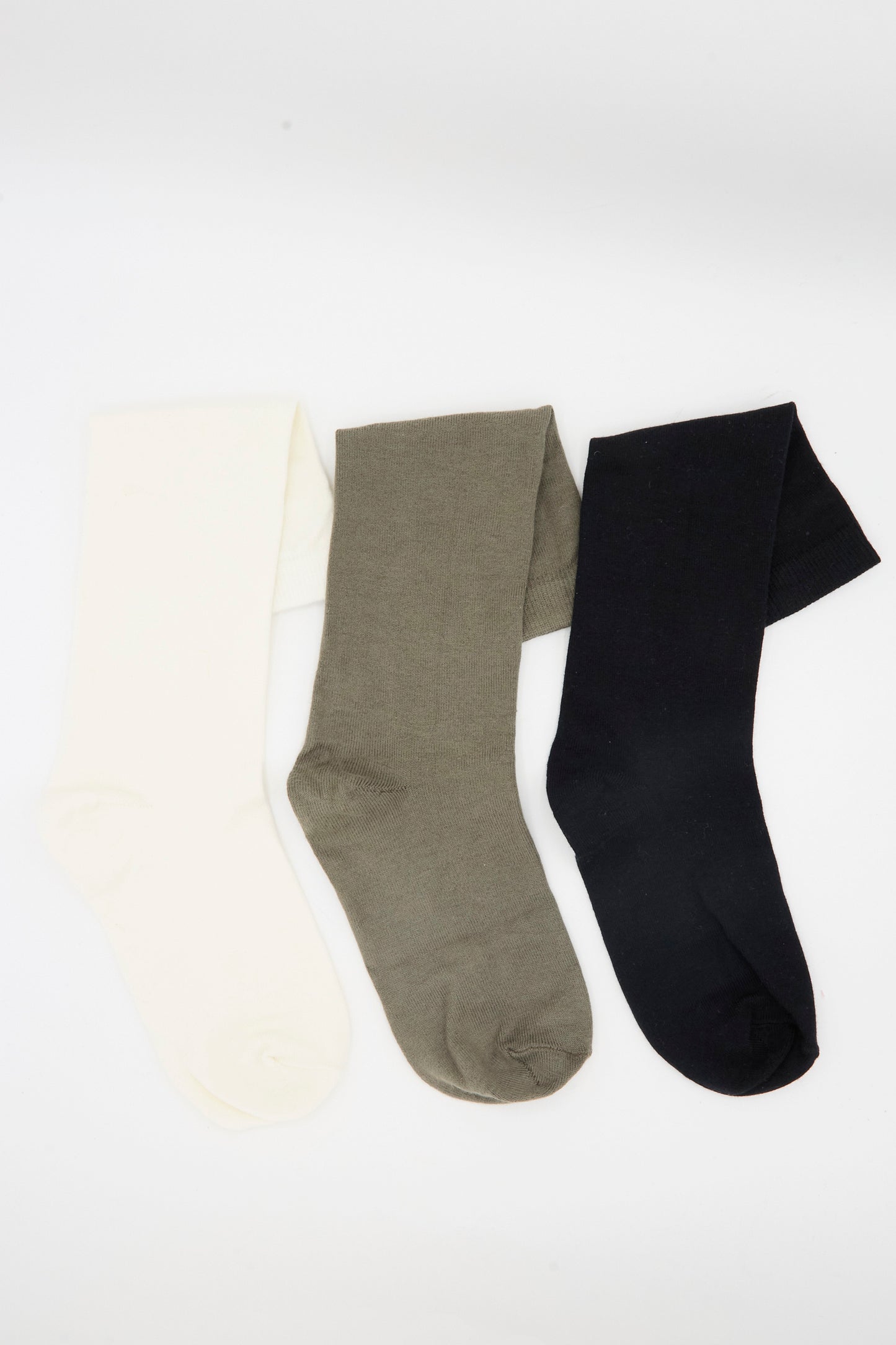 Three pairs of Lauren Manoogian Tall Socks in Mix—knee-high, made in Peru—are shown in cream, olive green, and black, laid side by side on a white background.