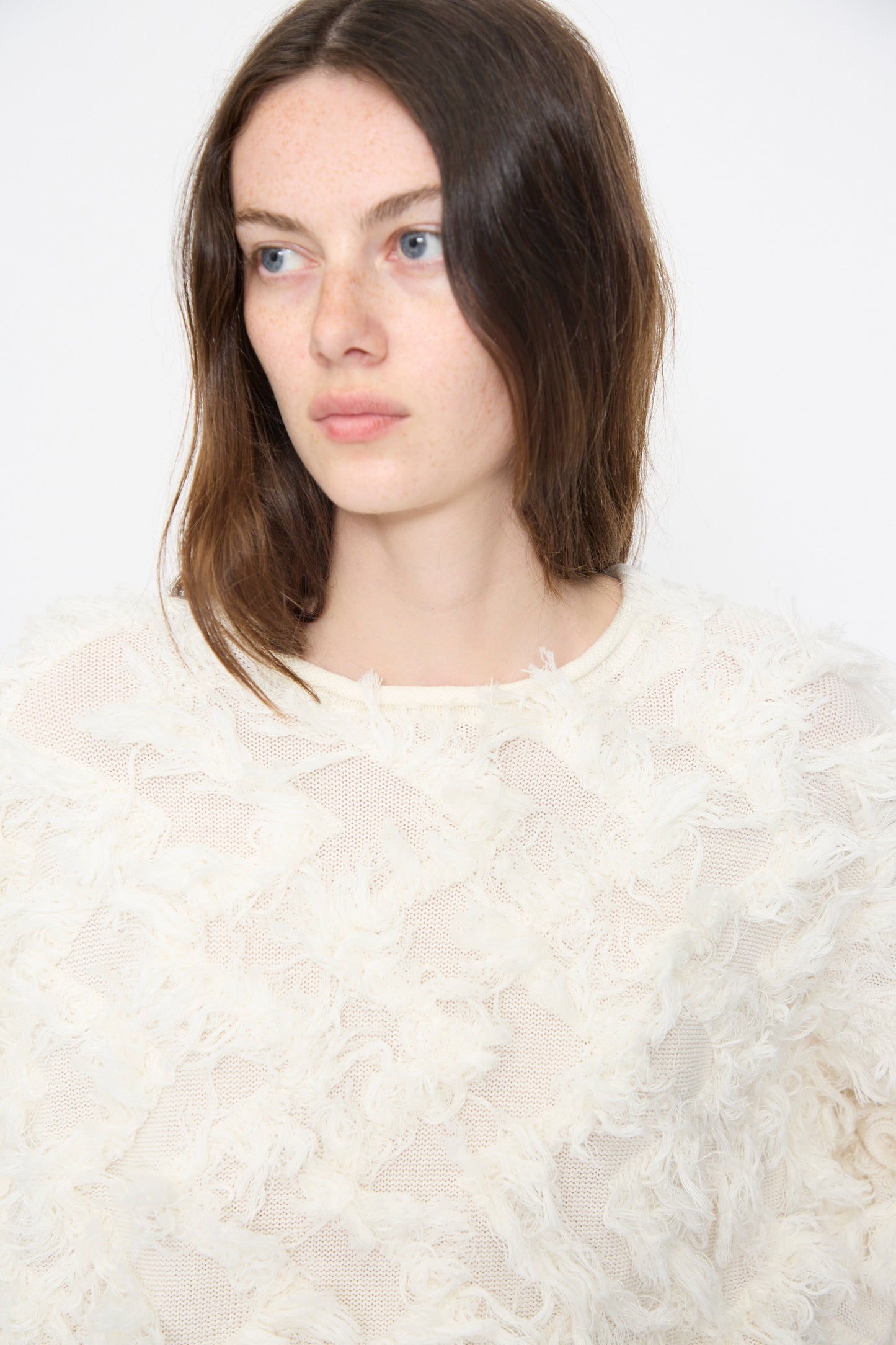 Model wears the Lauren Manoogian Tufted Pullover in Bone, an oversized cream knit sweater with fringe detailing.