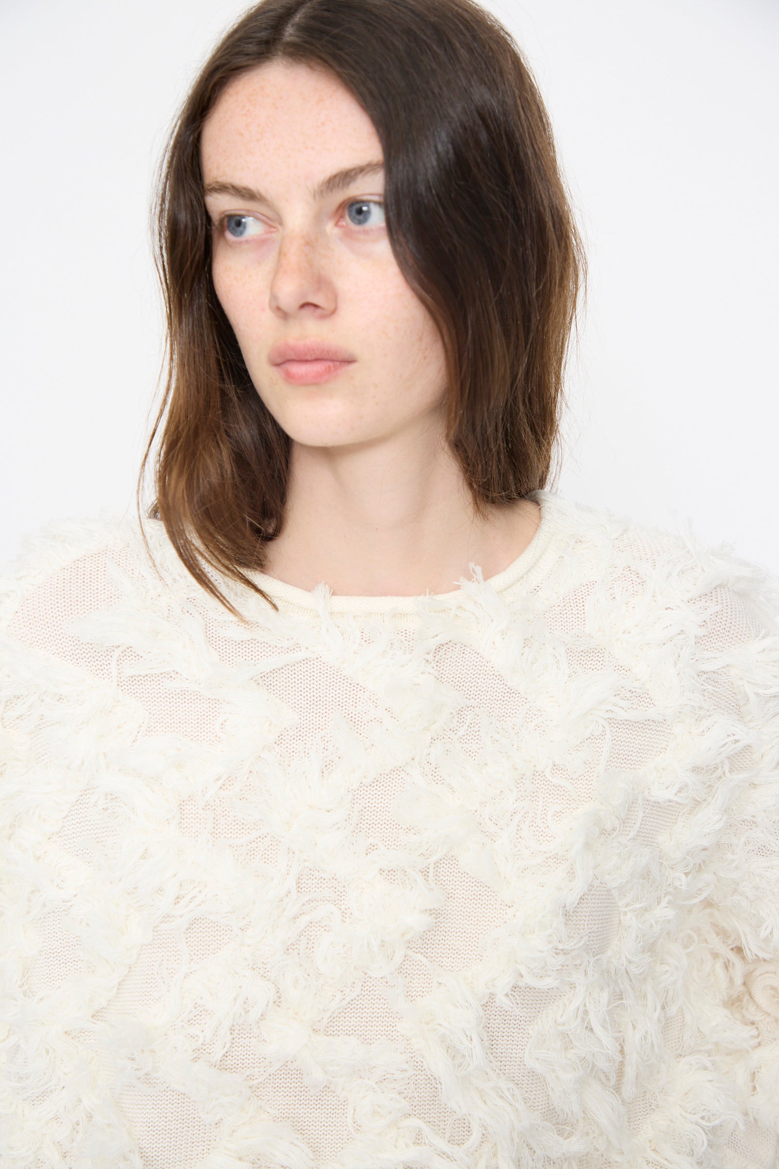 Model wears the Lauren Manoogian Tufted Pullover in Bone, an oversized cream knit sweater with fringe detailing.