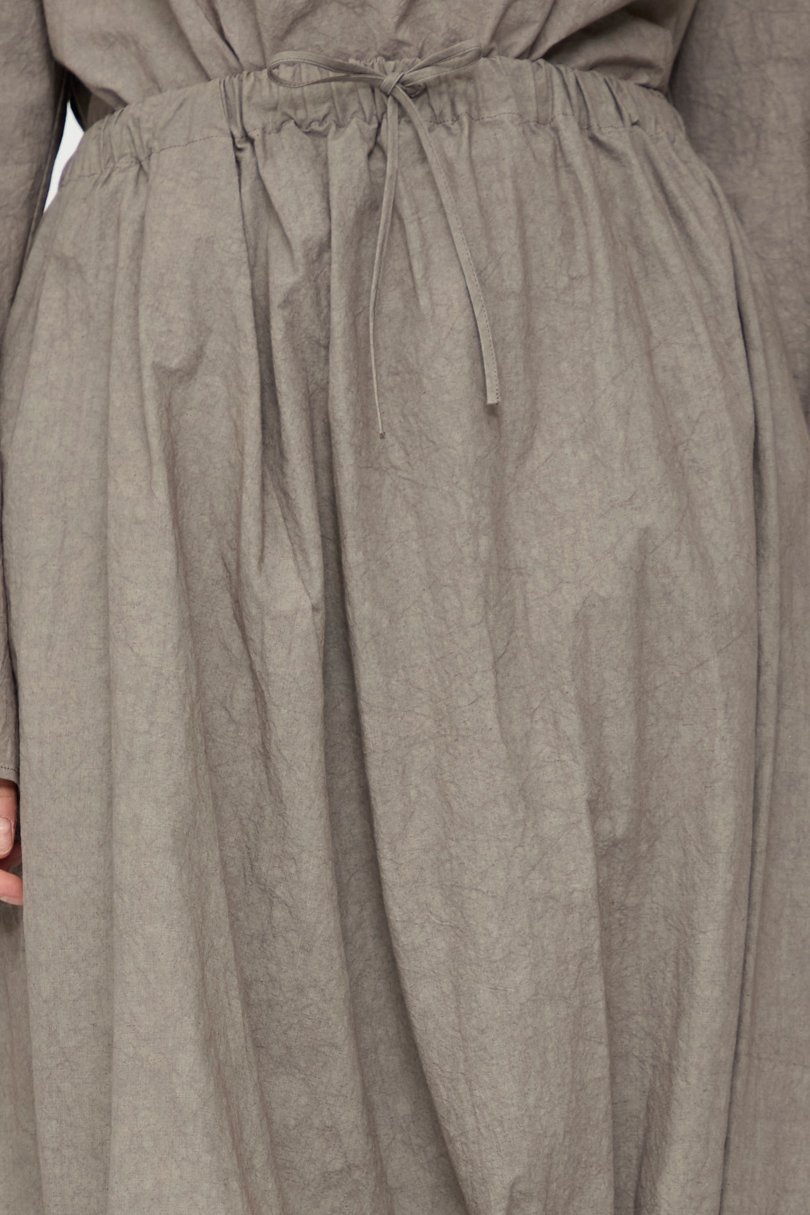 Close-up of the waist and skirt of Lauren Manoogian's Twist Skirt in Cinder, a gray crinkled cotton-linen maxi skirt with a drawstring waist, made in Japan.
