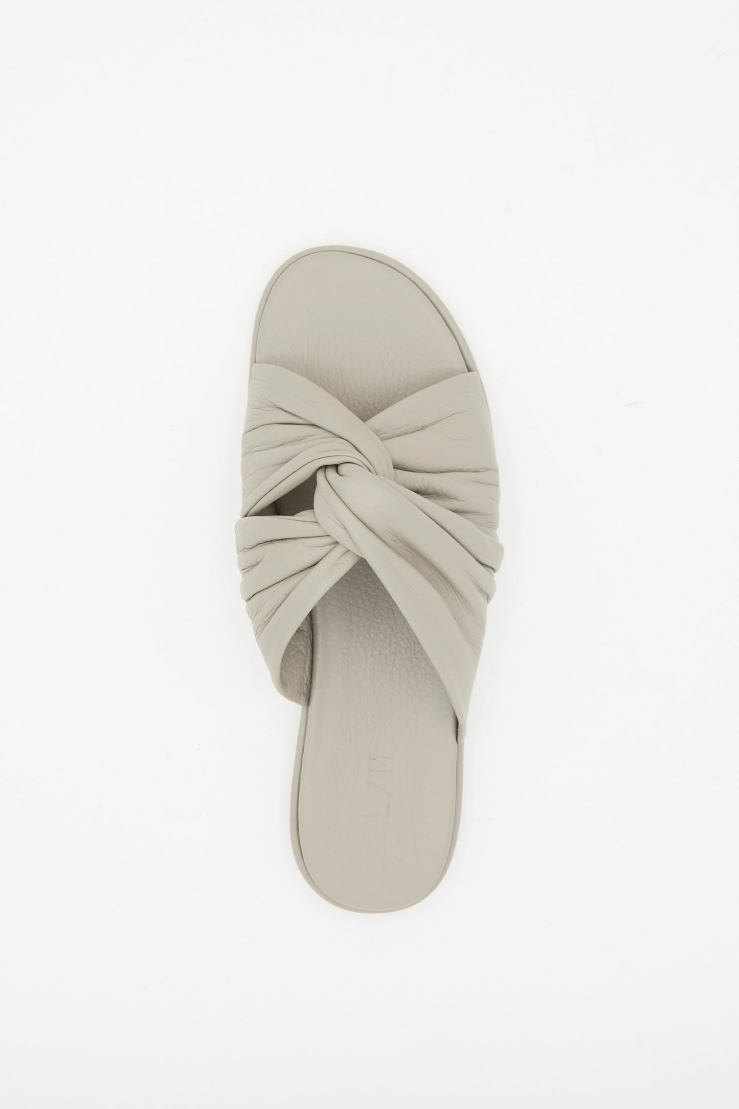 The Lauren Manoogian Twist Slide in Stone, a single light grey leather sandal with a twist vamp design, is photographed from above on a white background.