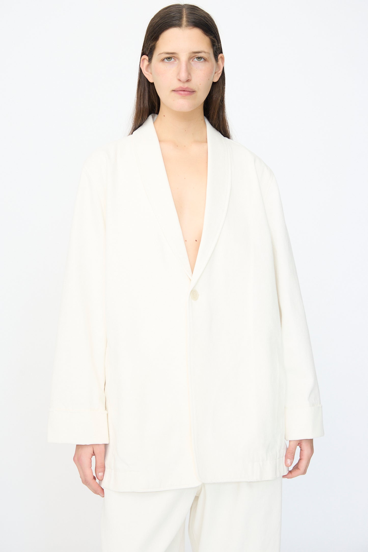 A person with long brown hair wears the Lauren Manoogian Washed Jacket in White, standing against a plain white background.