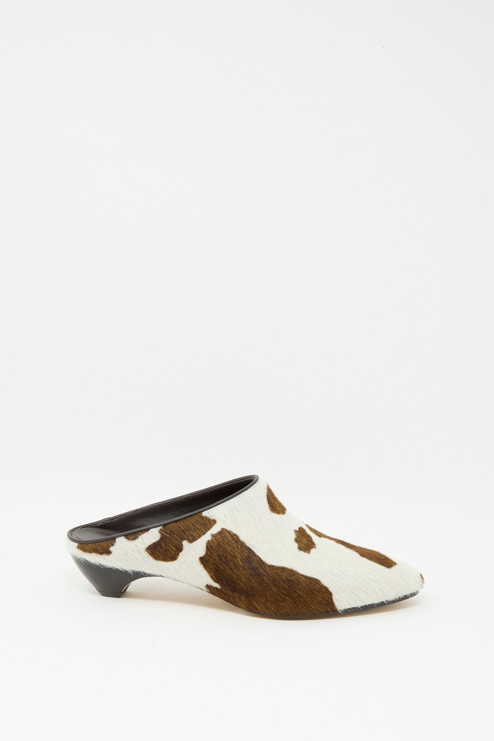 The Allegra Mule in Cow by Le Monde Beryl features a chic brown and white cow print in calf hair leather, finished with a sleek low black heel.