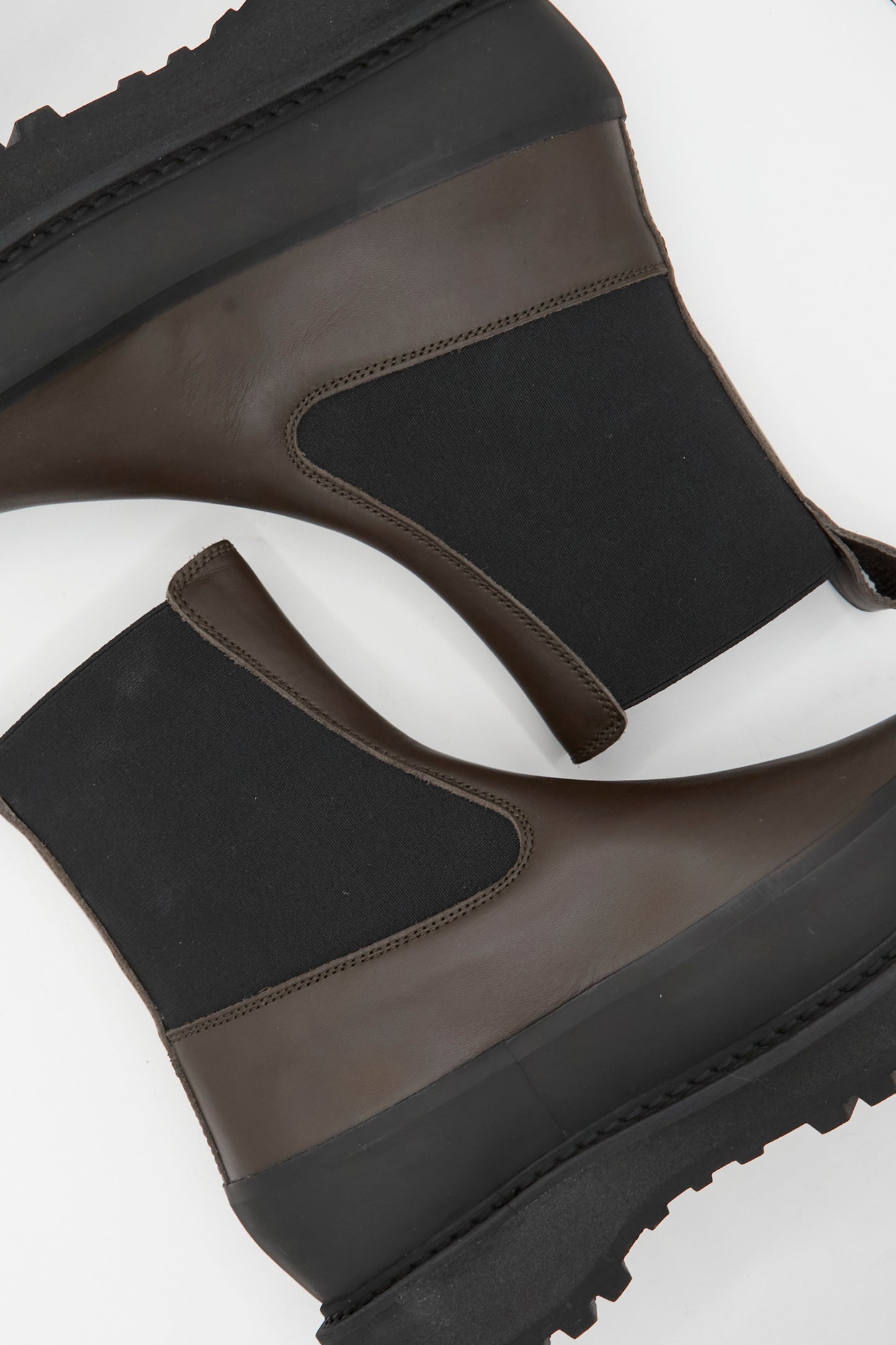 The Le Monde Beryl Chelsea Dolomite in Chocolate are dark brown calf leather Chelsea boots with chunky, ridged soles and a pull-tab, shown from above against a white background.