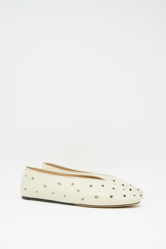The Eyelet Studded Leather Regency Slipper in Ecru by Le Monde Beryl features flat off-white leather, small metallic studs throughout, and a cushioned insole, displayed against a plain white background.