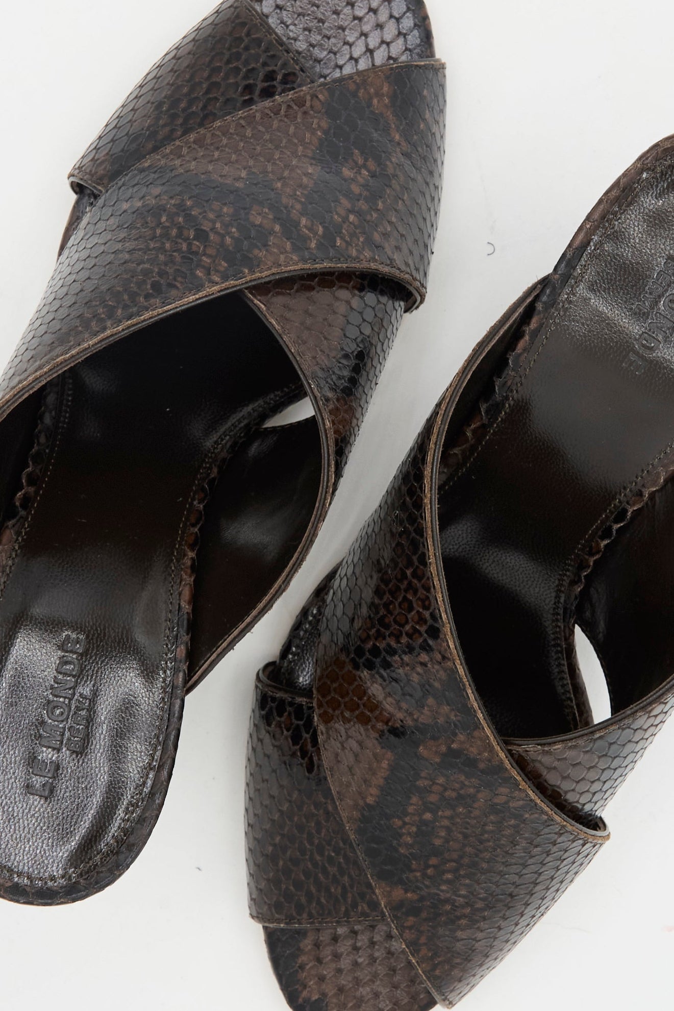 The Luca Mule in Snake Chocolate by Le Monde Beryl showcases brown snakeskin-patterned calf leather and crisscross straps, displayed on a light background.
