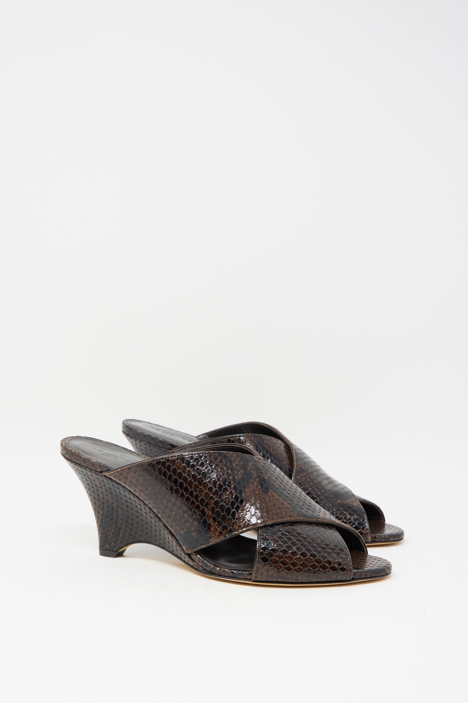 The Luca Mule in Snake Chocolate by Le Monde Beryl features dark brown, open-toe wedge sandals made of luxurious calf leather with a shiny snakeskin finish, shown against a white background.